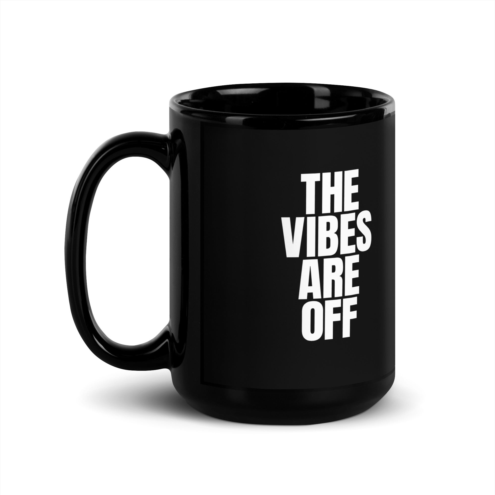 A 15 ounce black glossy coffee mug featuring 'THE VIBES ARE OFF' text in white, with the handle on the left side.