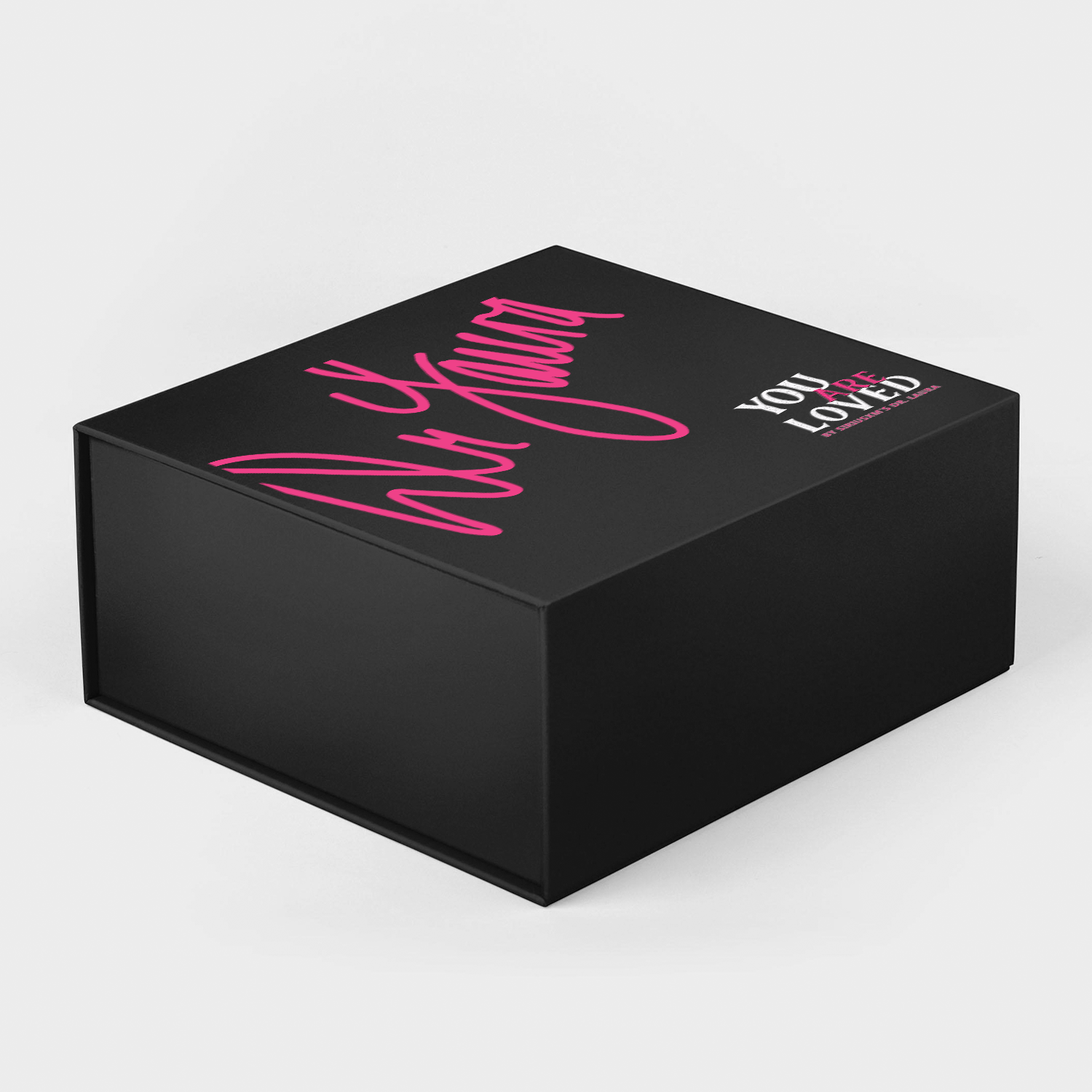 A black gift box with bold pink script reading ‘Dr. Laura’ and white text that says ‘You Are Loved by SiriusXM’s Dr. Laura.’