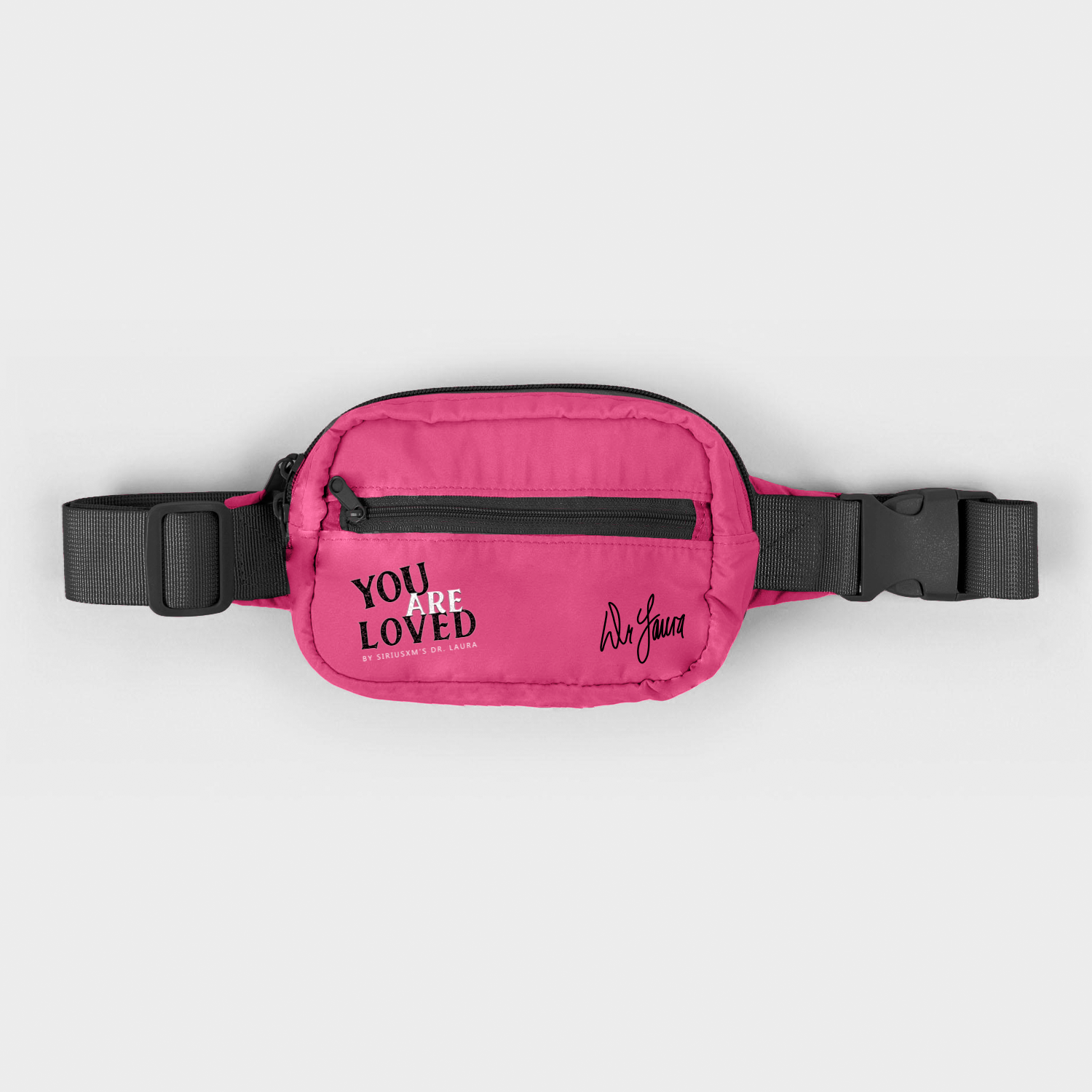 A pink hip pack with black straps and zipper, featuring black text that reads ‘You Are Loved by SiriusXM’s Dr. Laura’ and Dr. Laura’s signature.