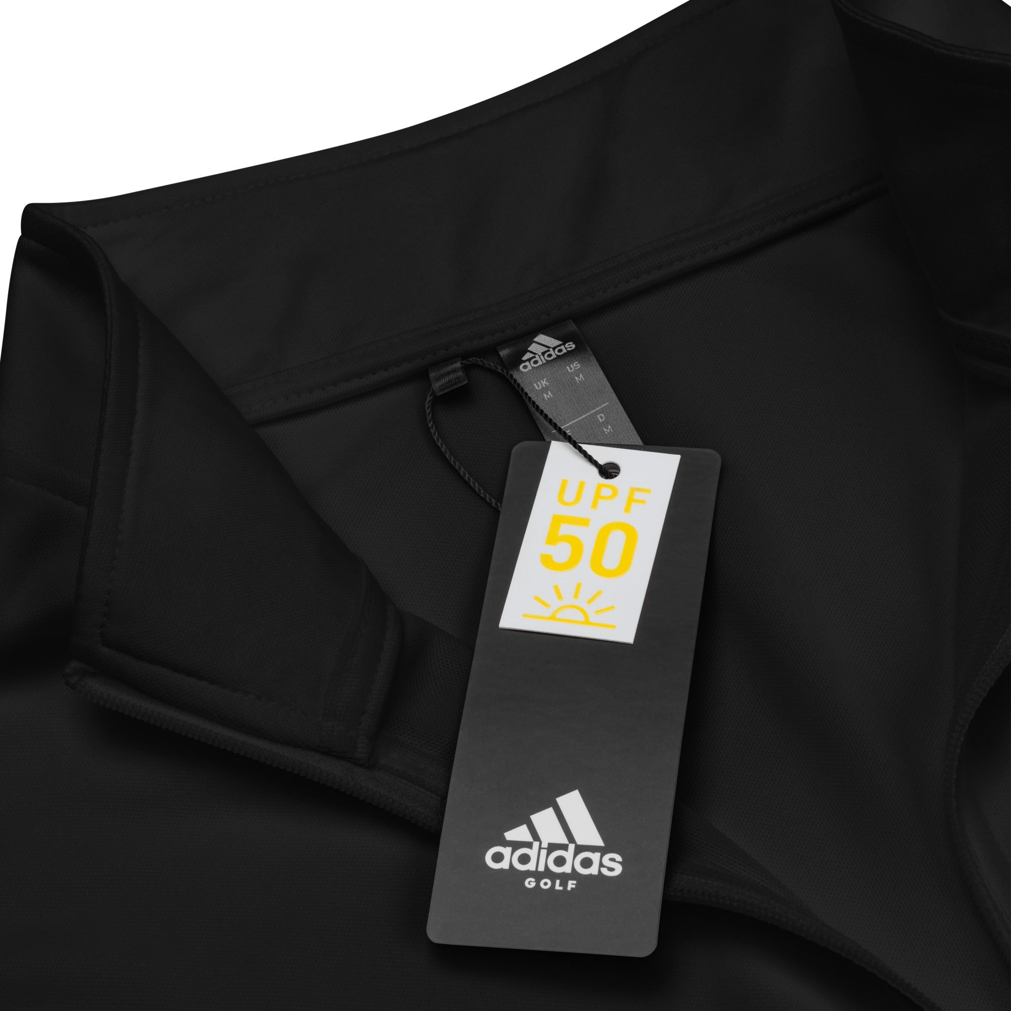 Black 'Adidas Golf' shirt tag displaying UPF 50 sun protection rating.