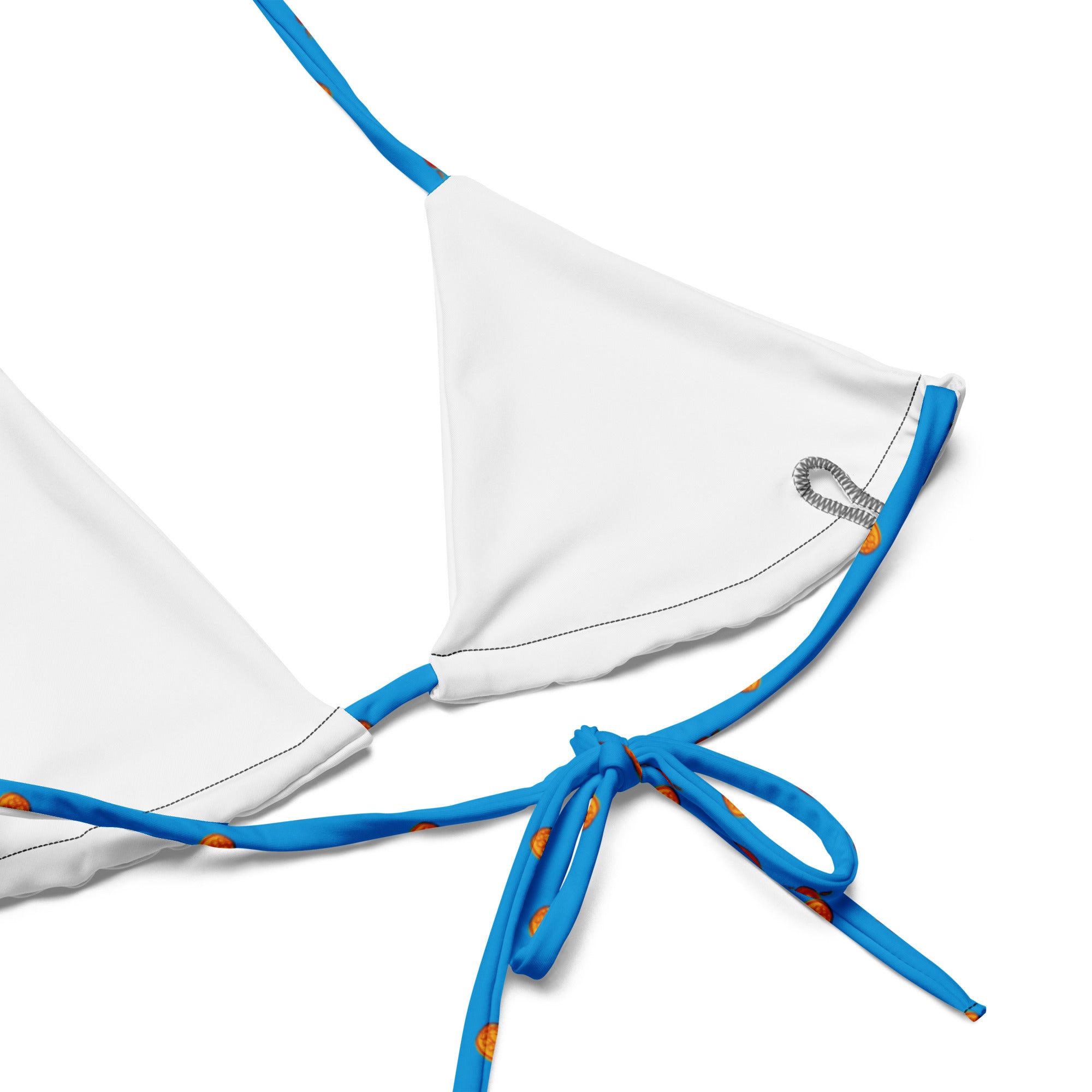 A close-up of the inside of a white bikini top showing the stitching, seam construction, and removable pad pocket, with blue straps printed in the red and yellow motorcycle design extending from the corners.