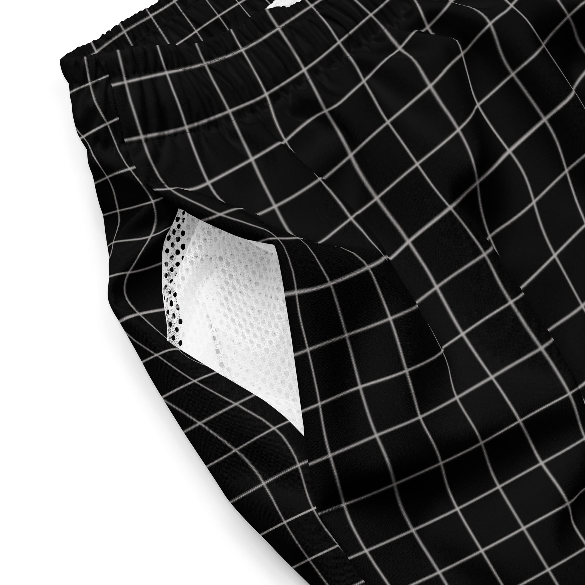 A close-up of the outer side of the black swim trunks, showing the white grid pattern and a partial view of the white mesh pocket lining inside. The waistband is gathered with elastic, and no visible logos or text are present.