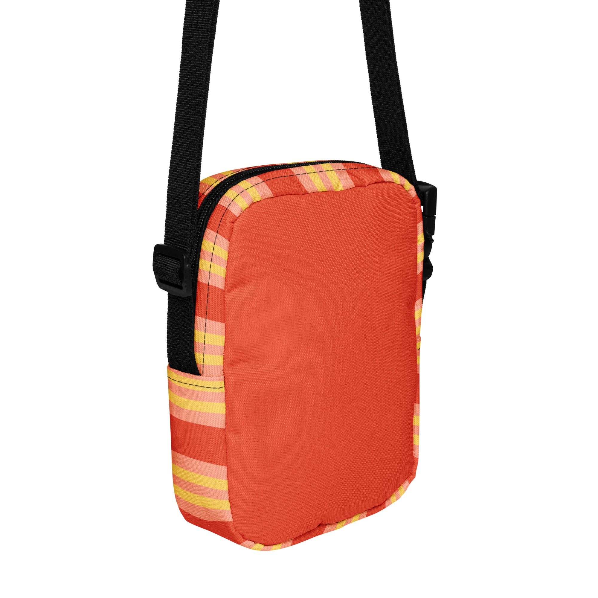 Angled back view of a small rectangular crossbody bag with an adjustable black strap. The bag is orange with yellow and light pink vertical stripes along the edges.