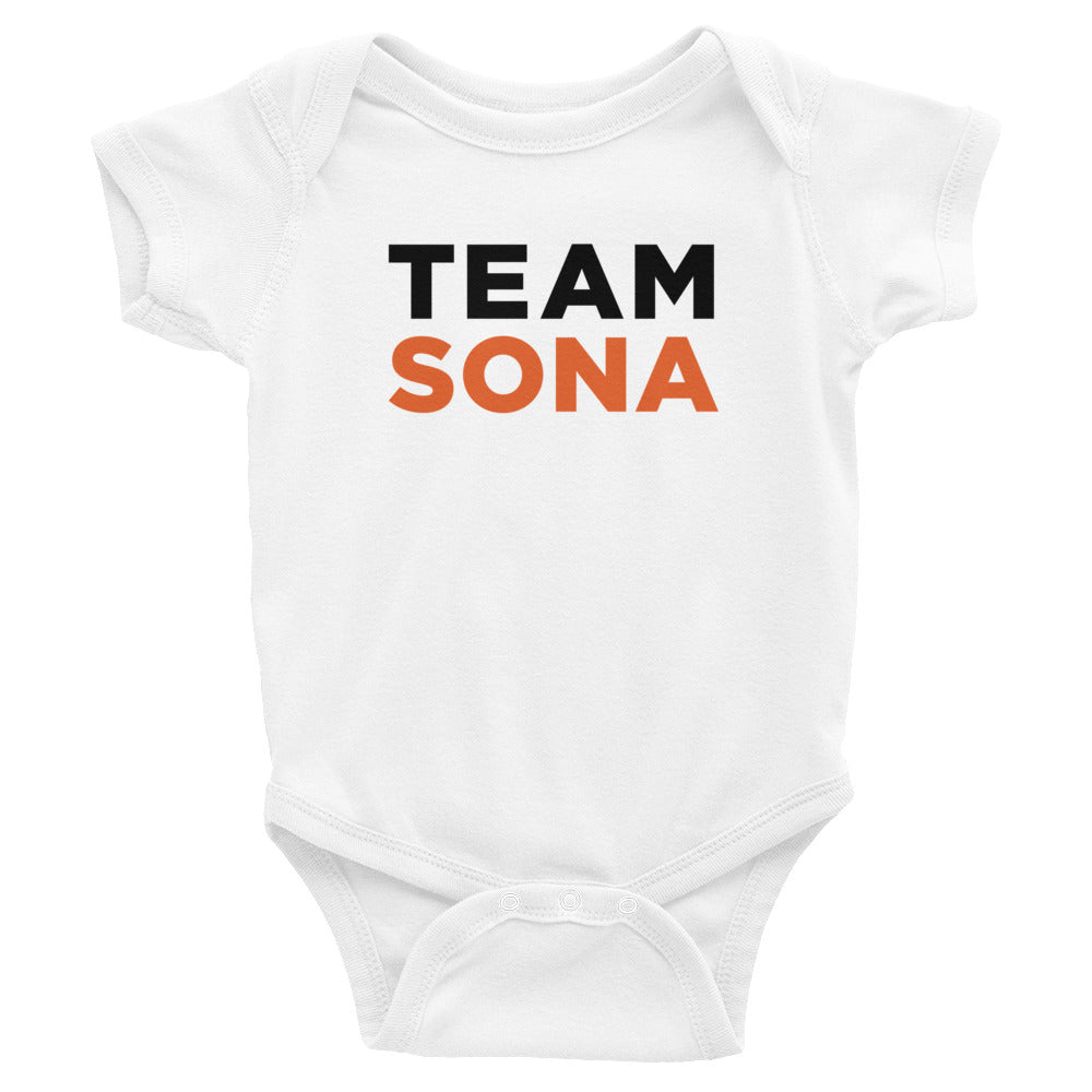 White baby onesie featuring the text 'TEAM SONA' in black and orange.