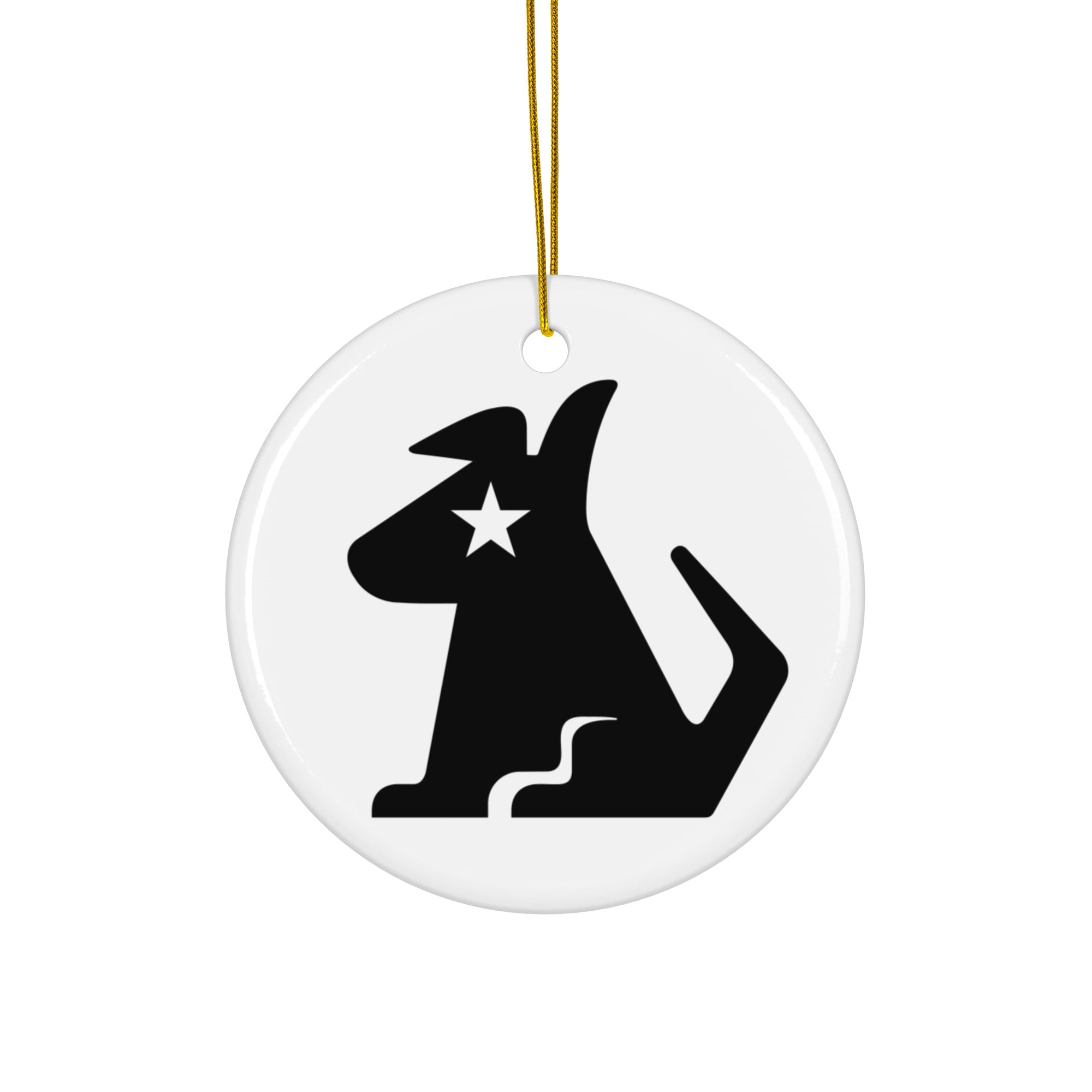White ceramic ornament hanging from a gold string, printed with the black Stella Dog logo, showing the stylized dog with a star on her face and a curved tail.