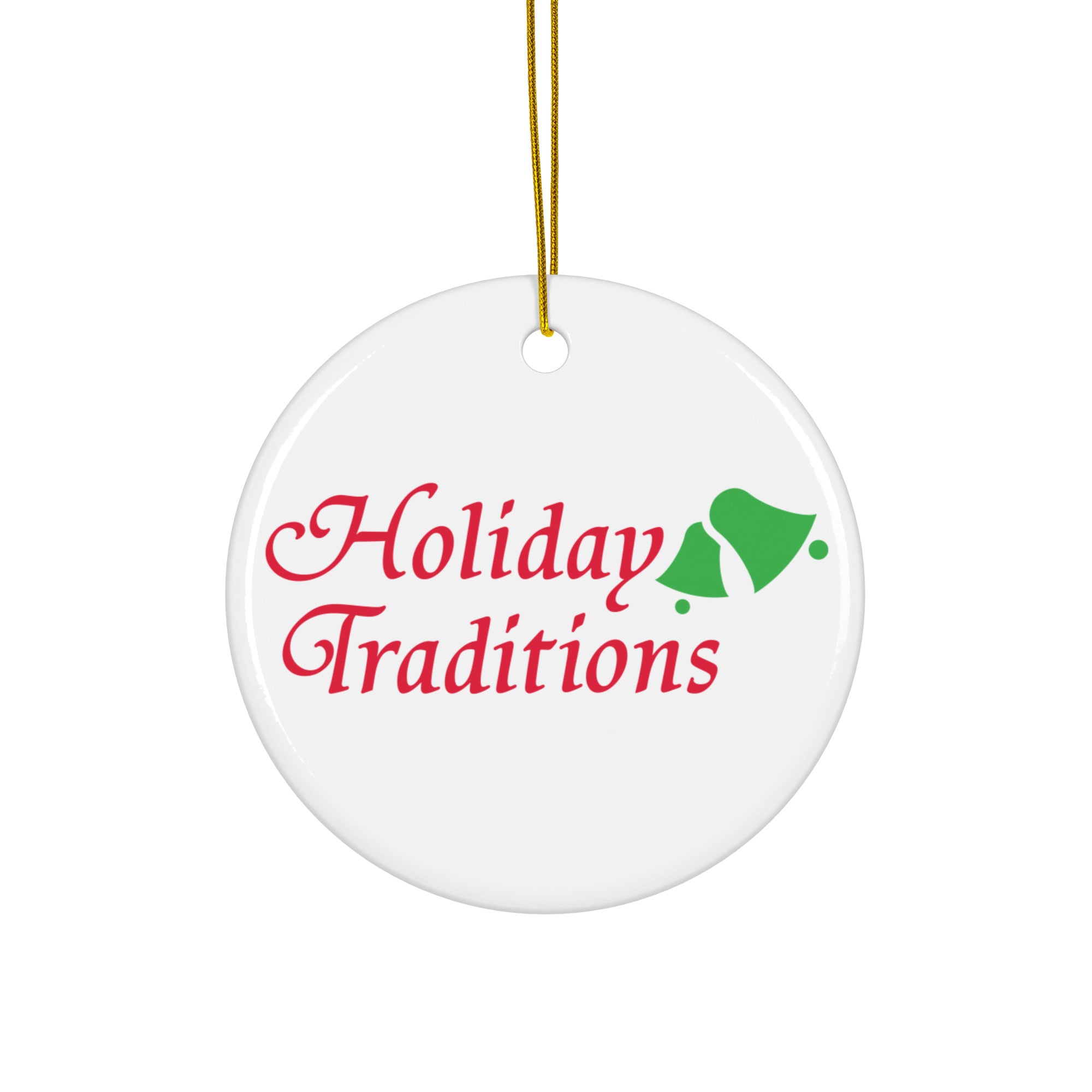 White round ornament hanging by a gold string, displaying the words ‘Holiday Traditions’ in red cursive lettering with a pair of green bells to the right.