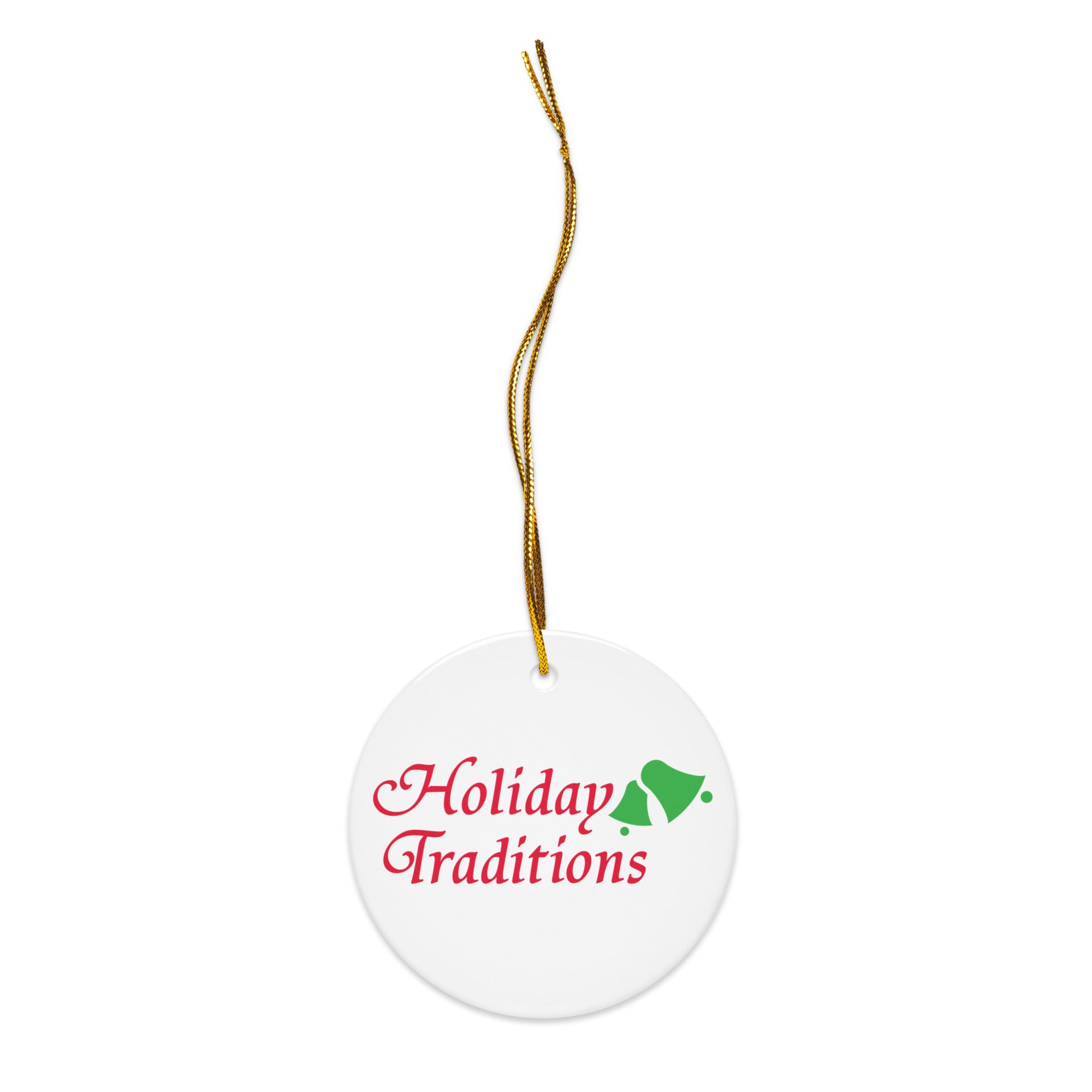 White ceramic ornament with a gold hanging string, printed with the words ‘Holiday Traditions’ in red script lettering and a green bell graphic beside the text.