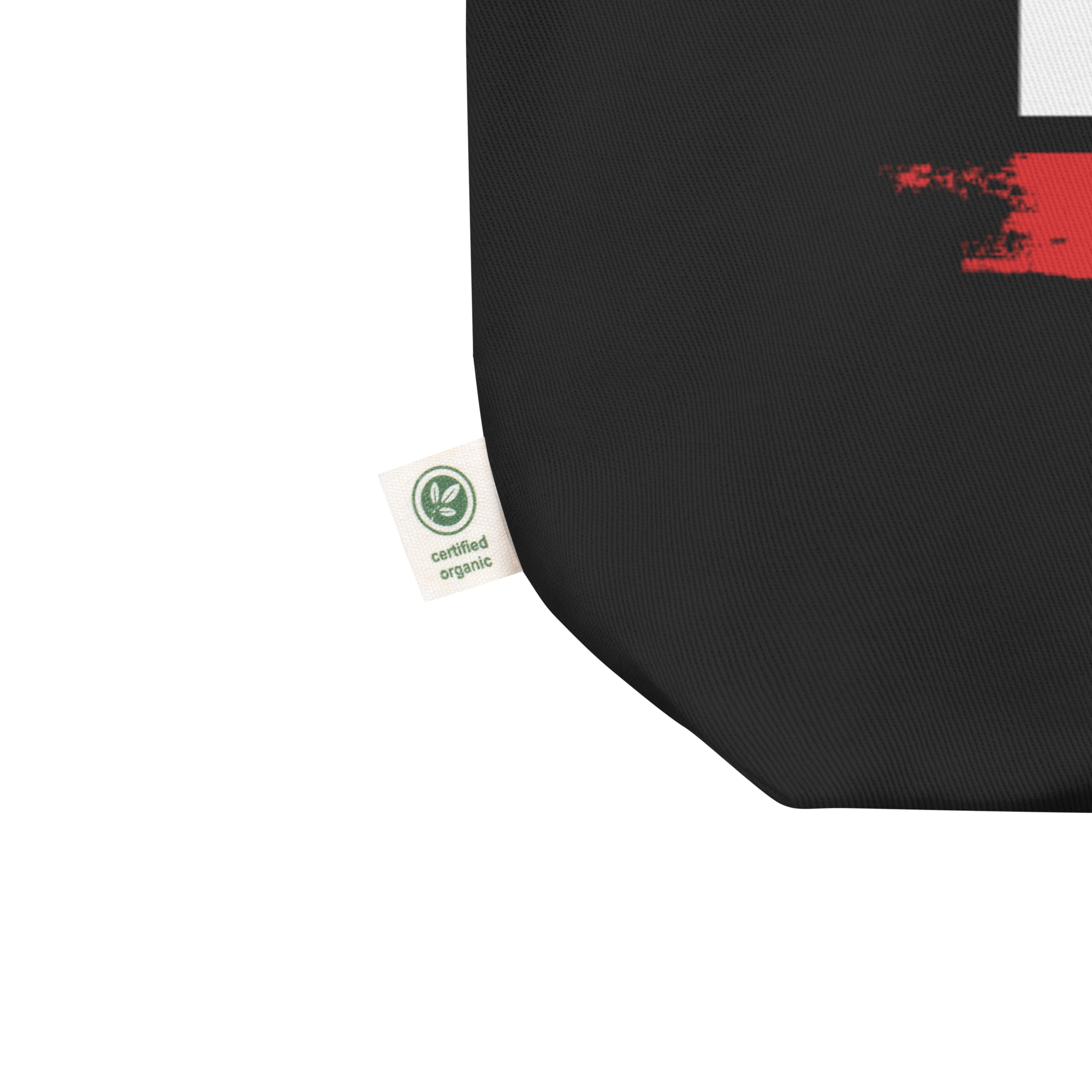 Close up of bottom left corner of black tote featuring the small manufacturer's tag reading 'certified organic' in reference to the canvas fabric.