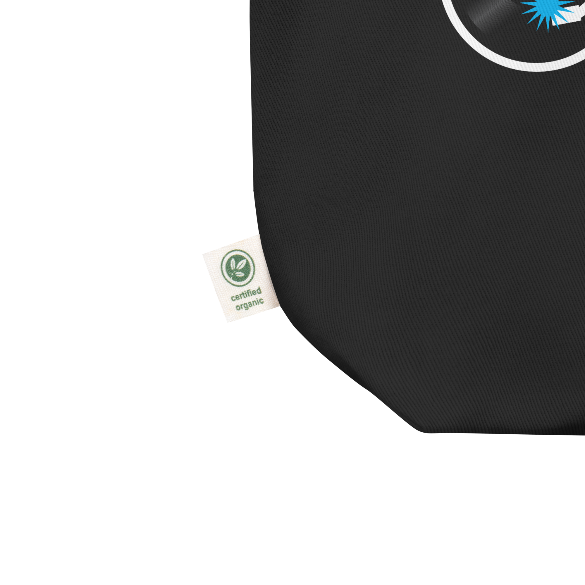 Close up of tote bag's lower left corner featuring manufacturer's tag that confirms canvas fabric is 'certified organic.'