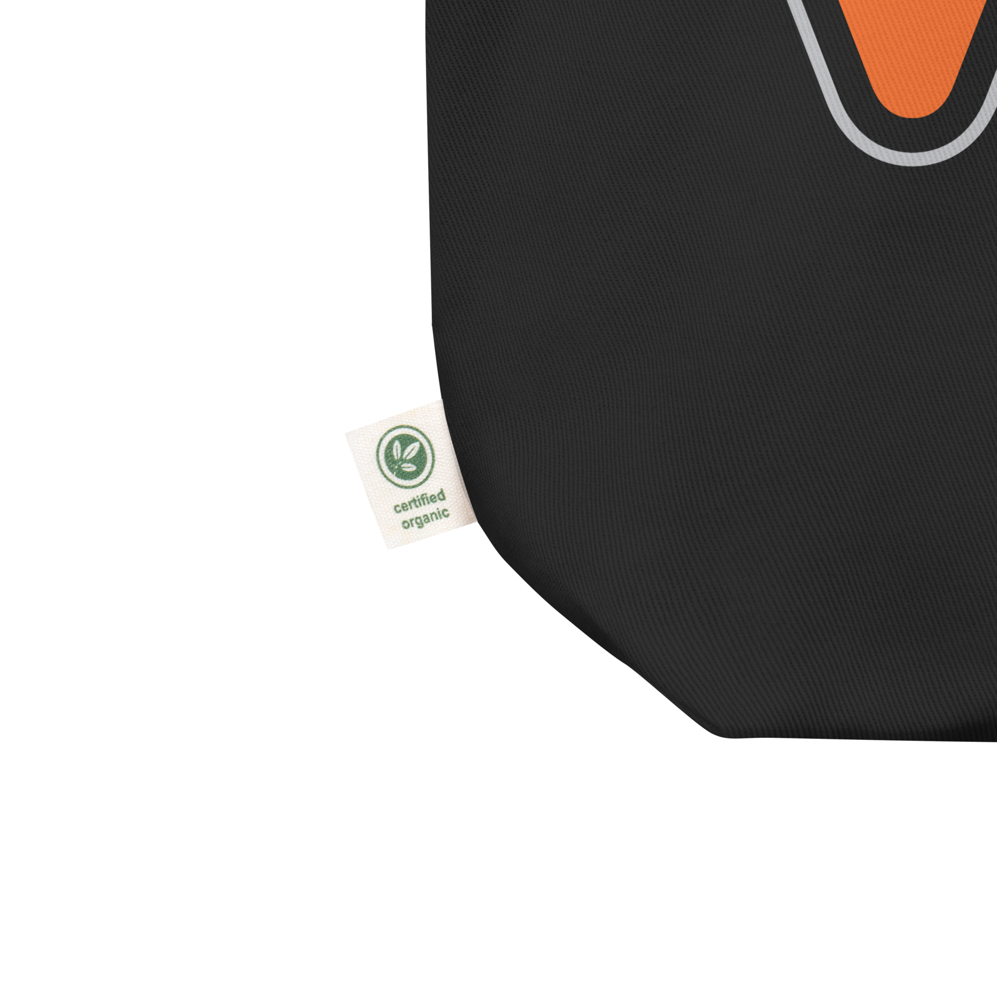 Close up of tote bag's lower left corner featuring manufacturer's tag that confirms canvas fabric is 'certified organic.'