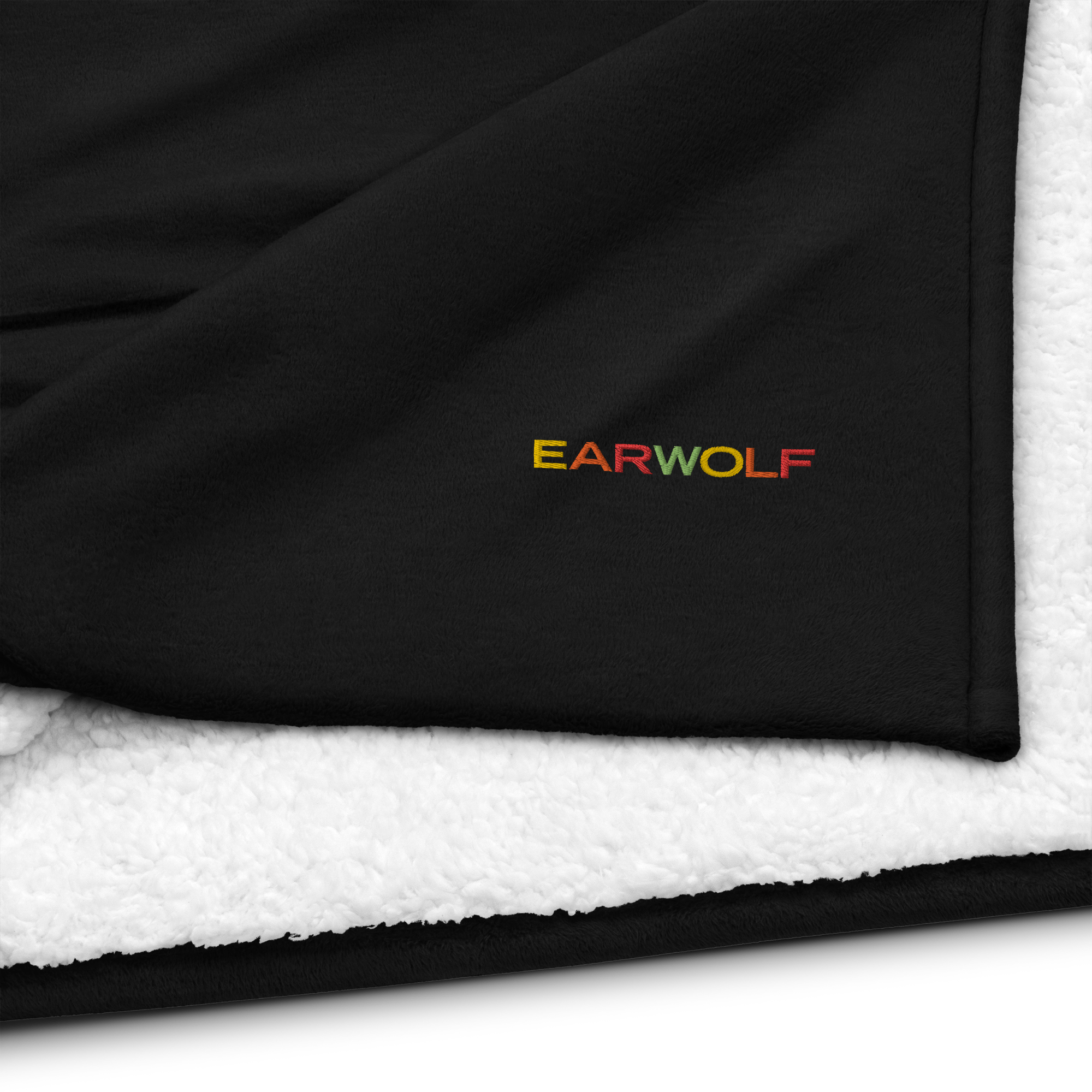 Black blanket featuring the embroidered logo 'EARWOLF' in yellow, orange, red, and green with white fleece on opposite side..