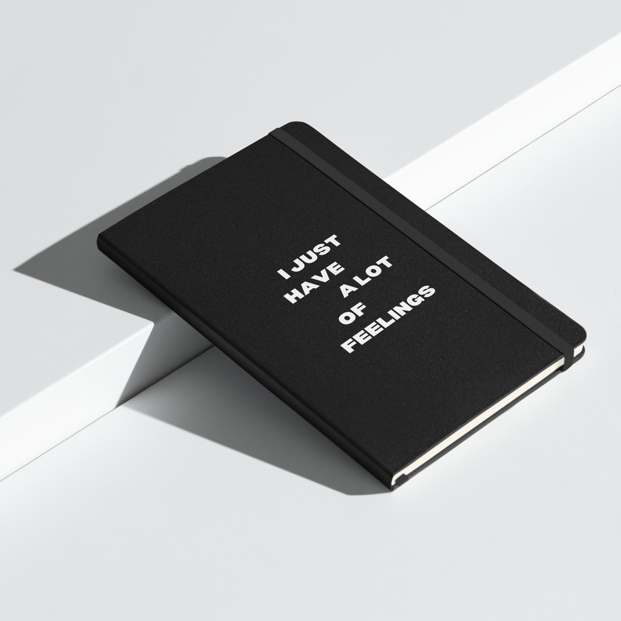 Black notebook with elastic band, featuring the text 'I just have a lot of feelings' in white font.