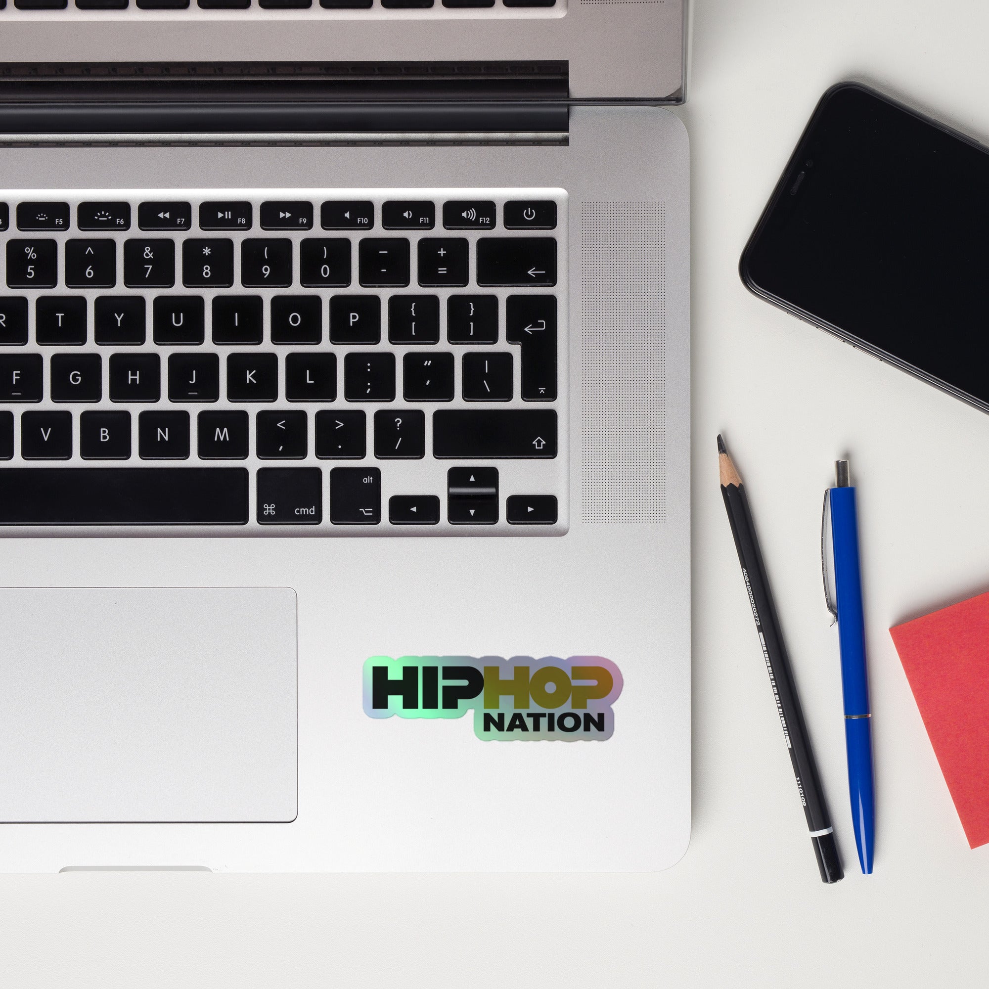 A laptop keyboard displaying a 'HIP HOP NATION' holographic sticker.