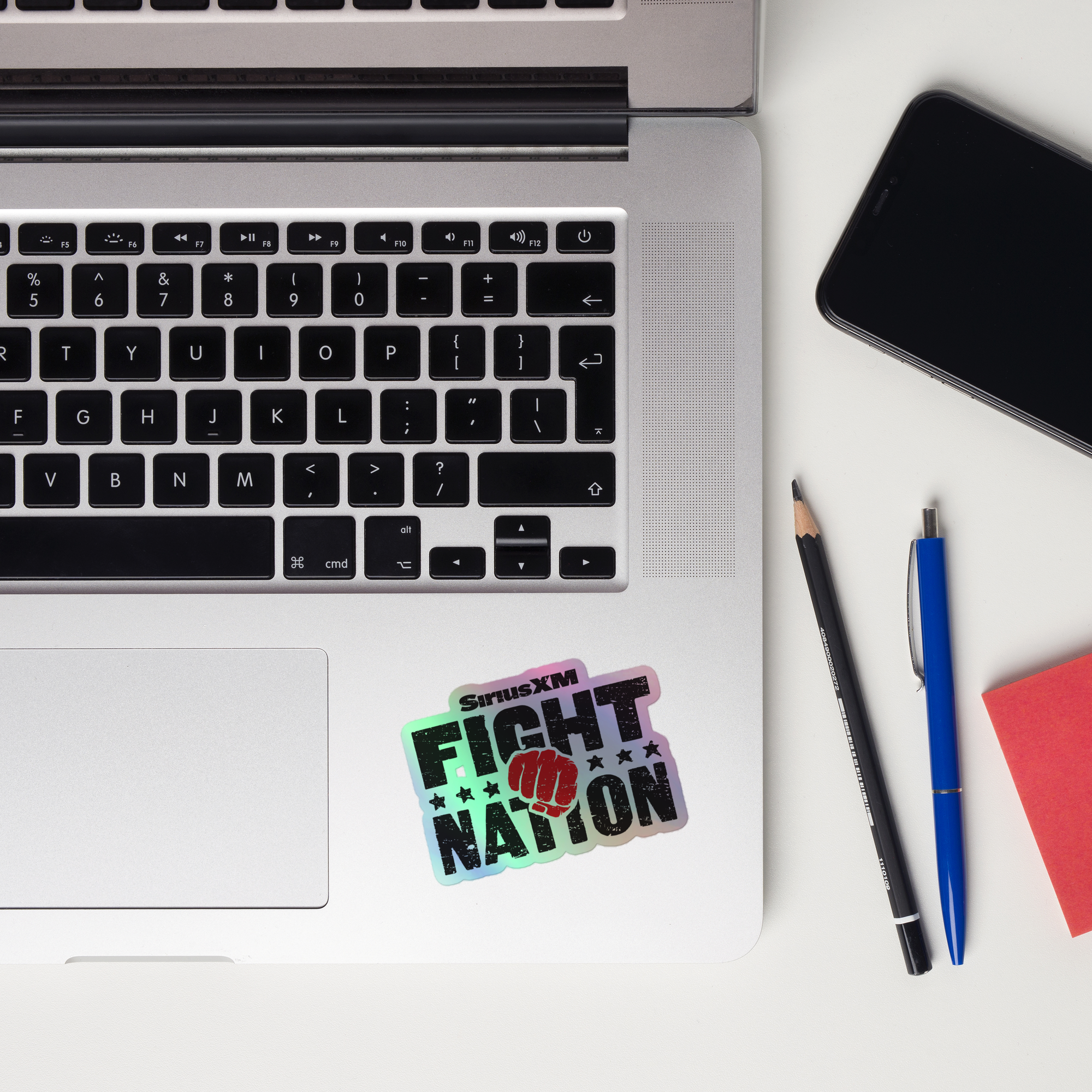 Laptop keyboard displaying a 'SiriusXM Fight Nation' holographic sticker.