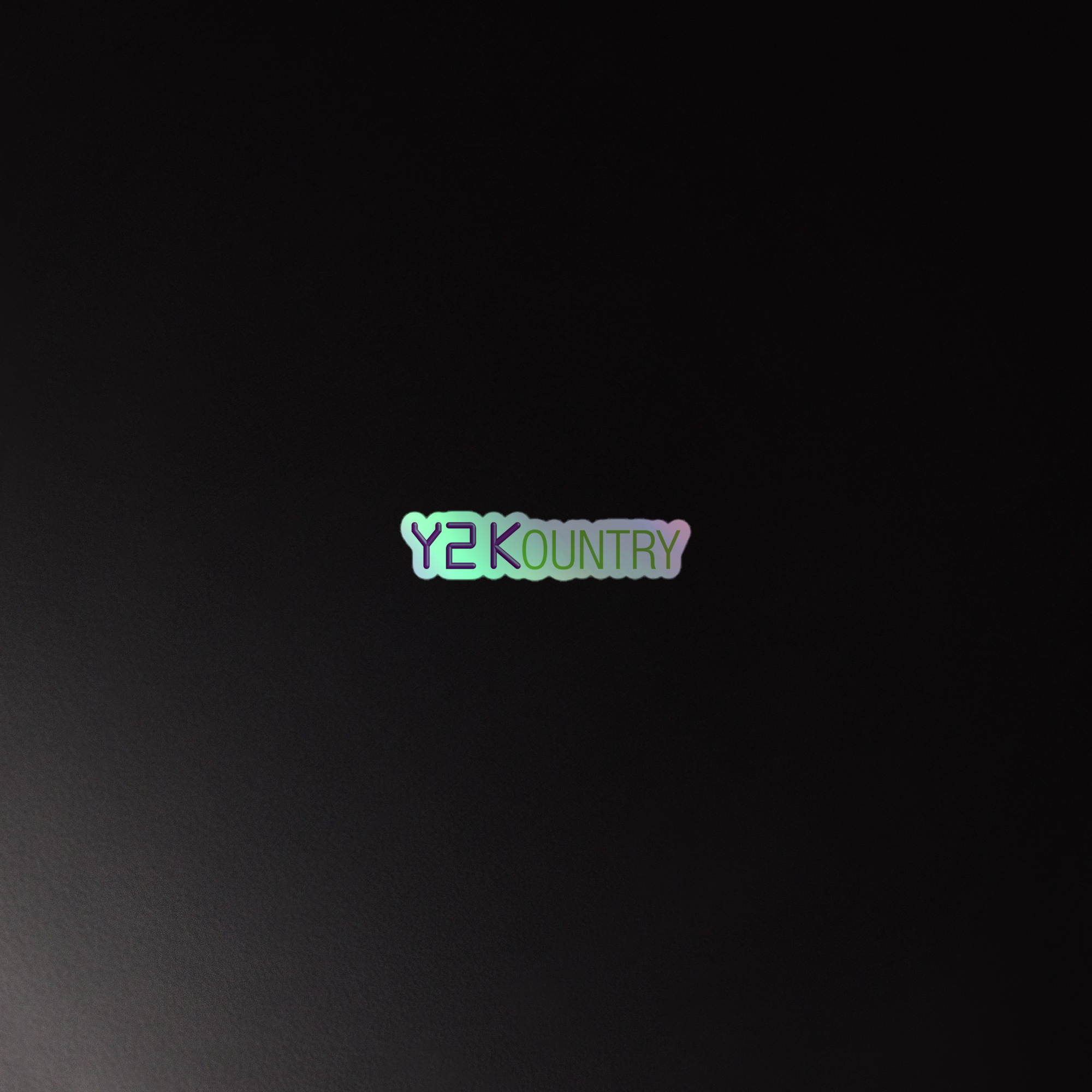 Holographic sticker of the olorful 'Y2KOUNTRY' logo on a dark background.