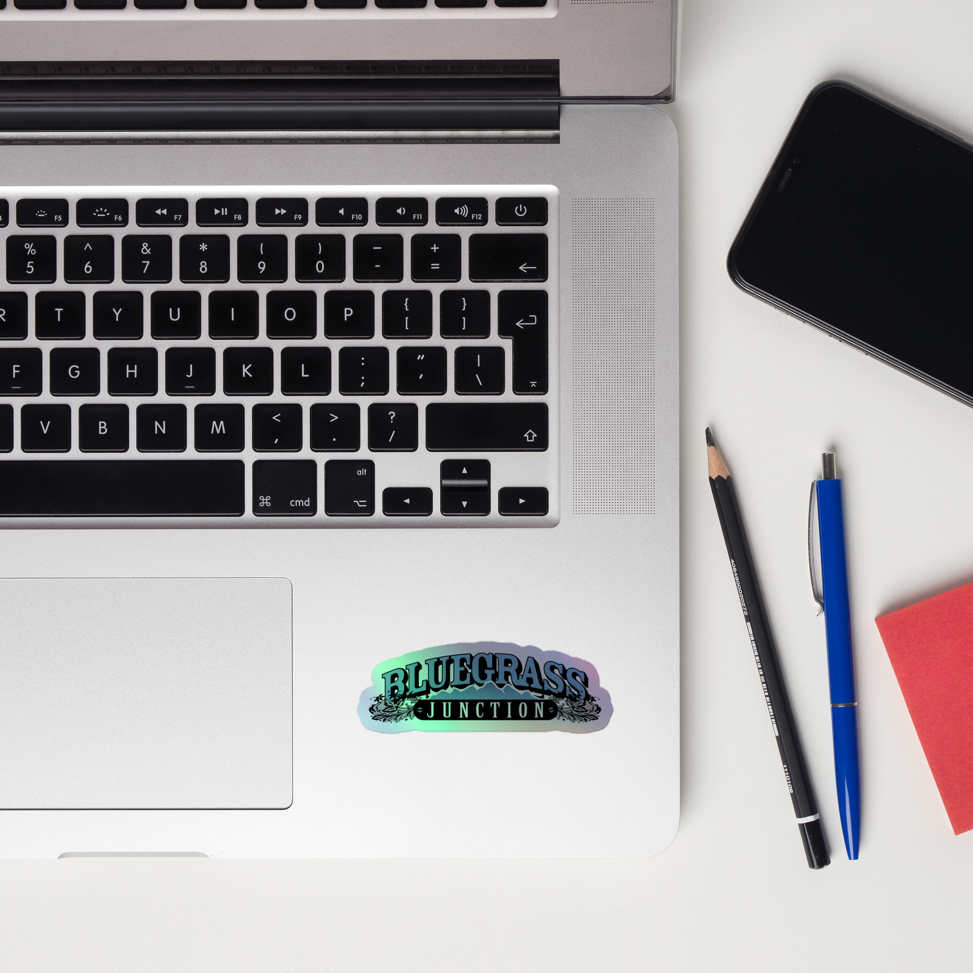 Laptop keyboard displaying a 'Bluegrass Junction' holographic sticker.