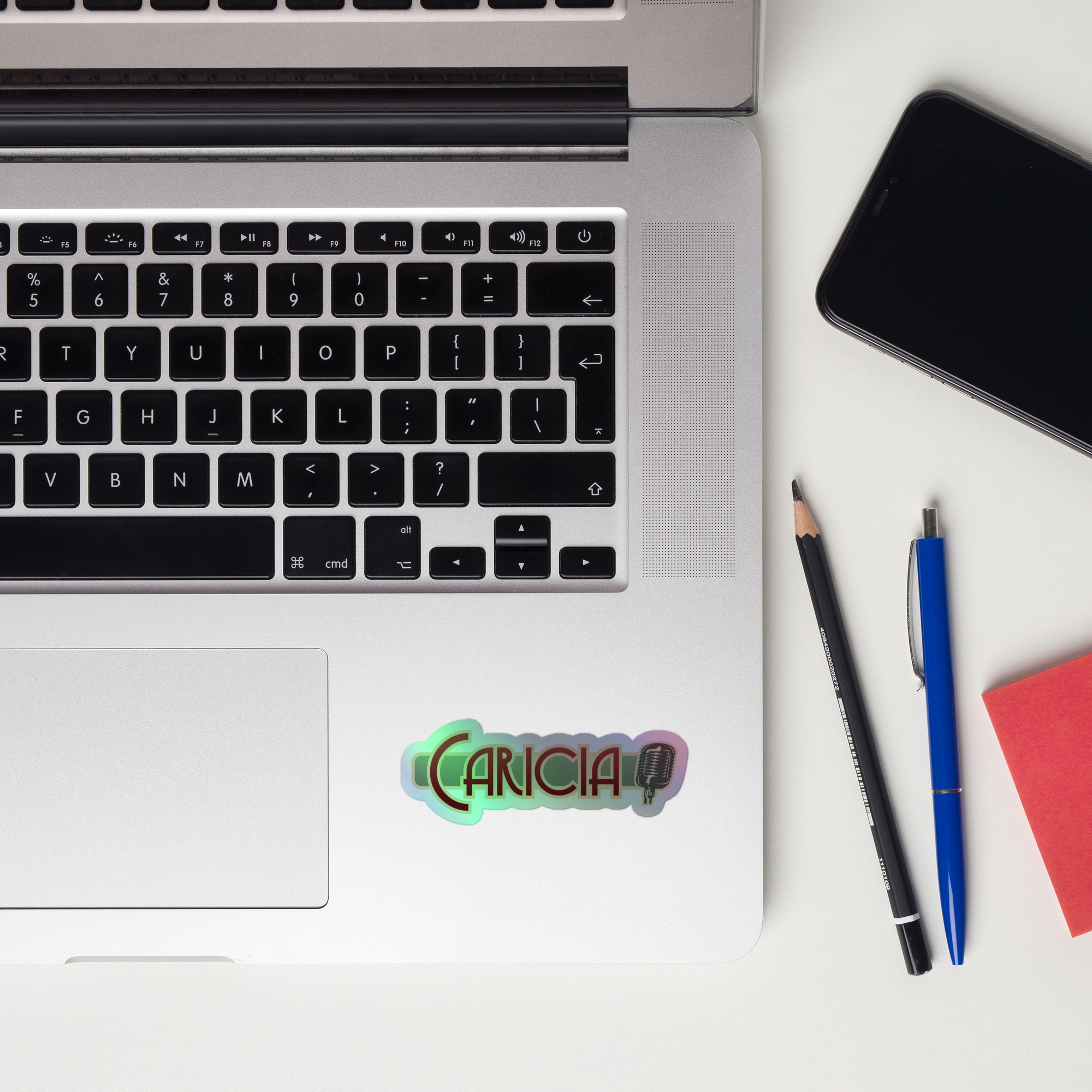 A laptop keyboard displaying a colorful 'Caricia' holographic sticker.