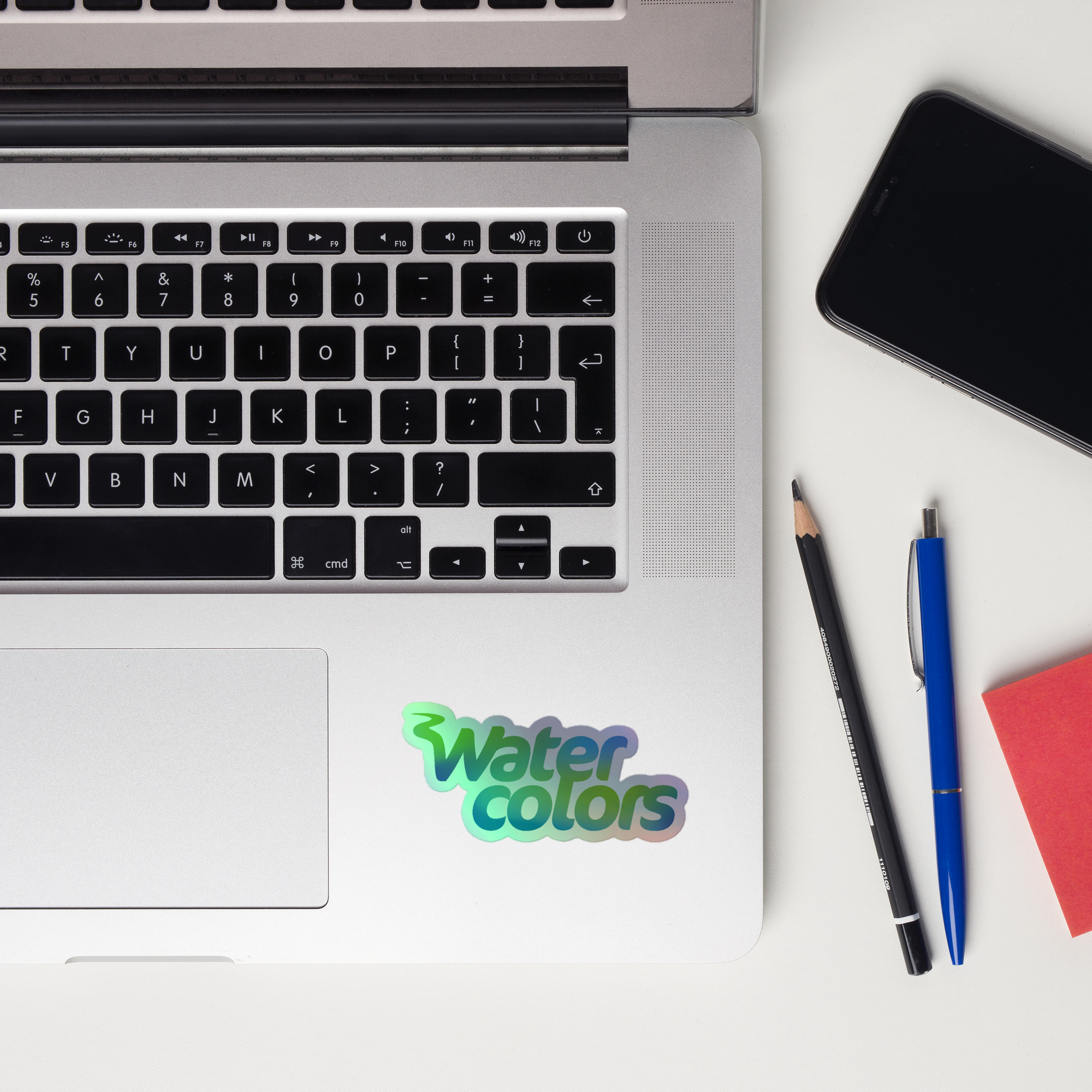 A laptop keyboard displaying a 'Water Colors' holographic sticker.