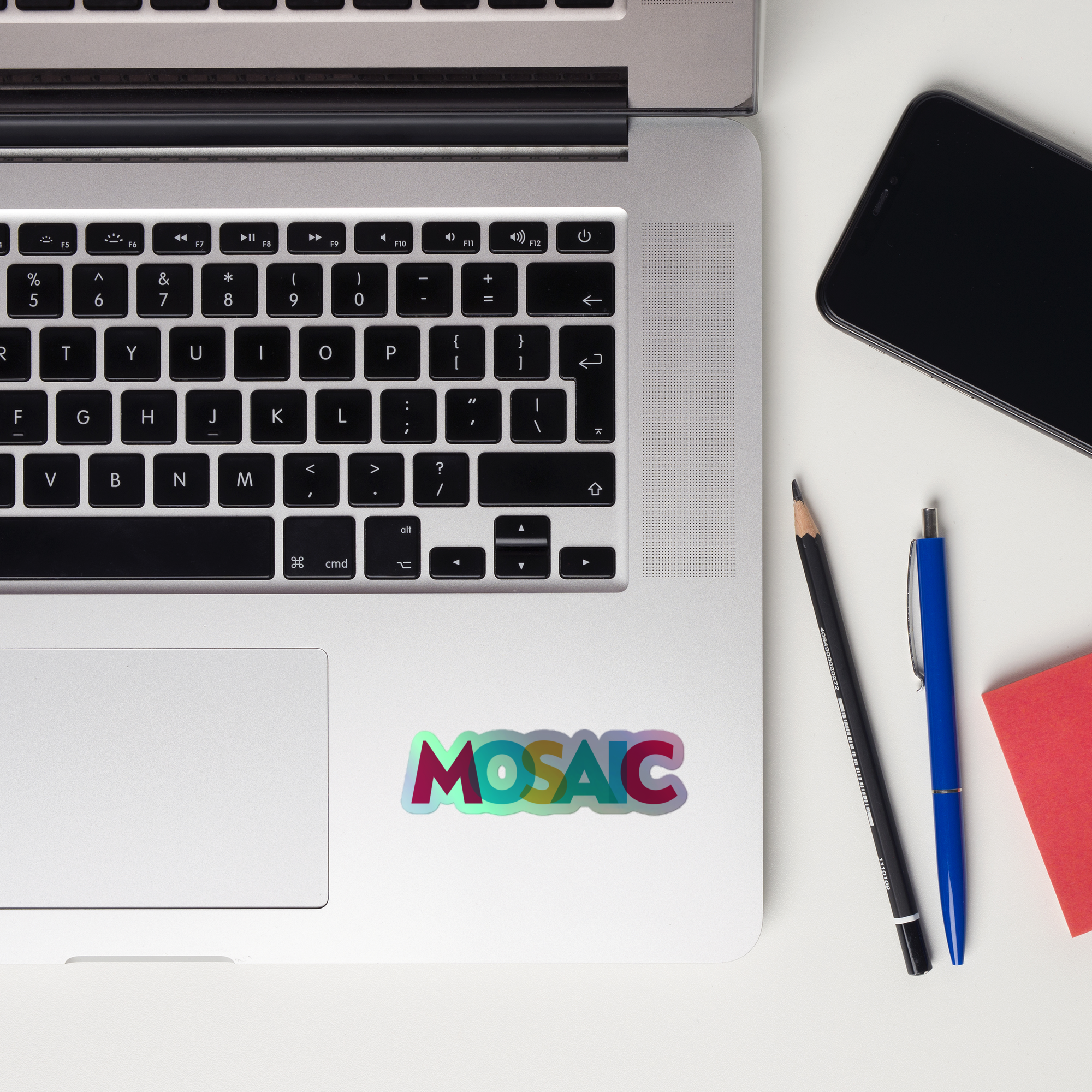 Close-up of a laptop keyboard displaying a colorful 'MOSAIC' holographic sticker.
