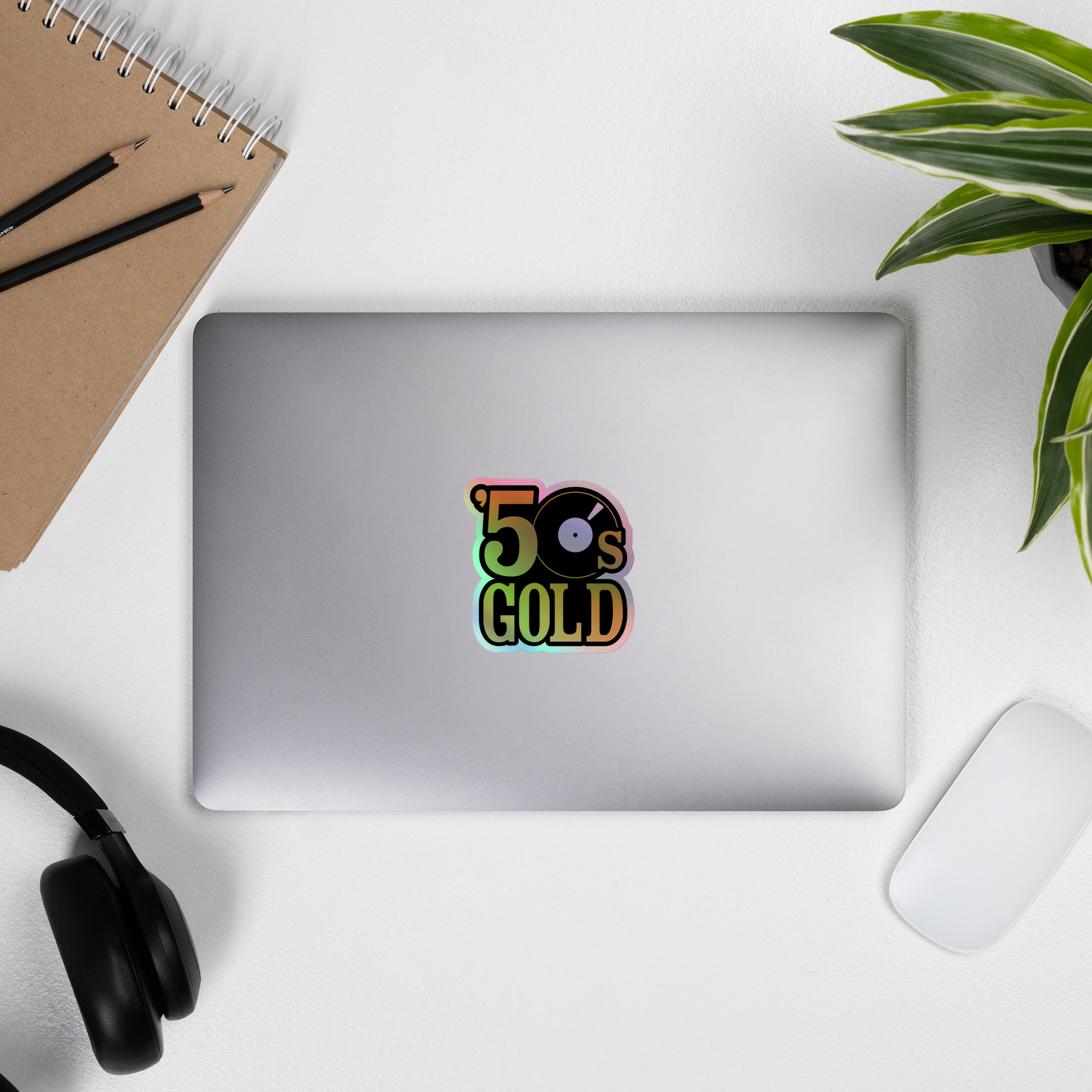 Laptop displaying a colorful '50s GOLD' holographic sticker.