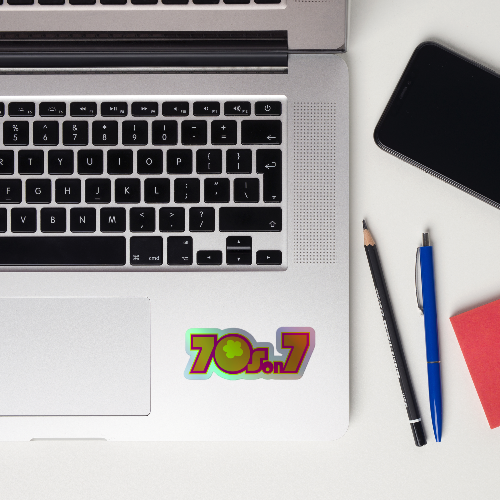 A laptop keyboard displaying a holographic sticker of the '70s on 7' logo.