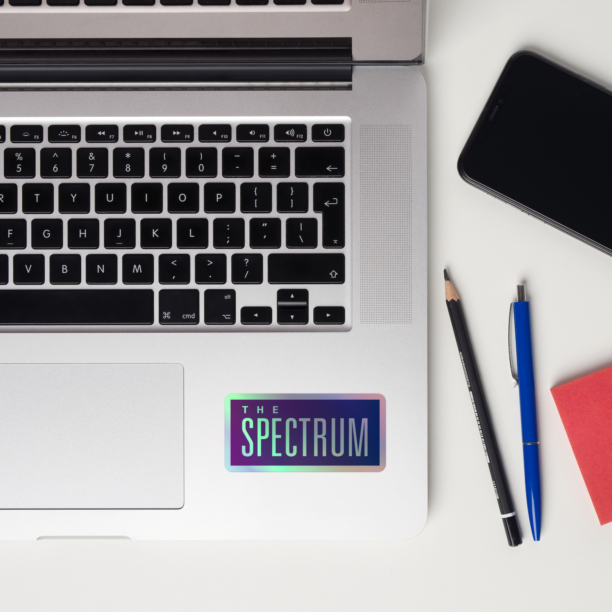A laptop keyboard displaying a holographic sticker reading 'THE SPECTRUM.'