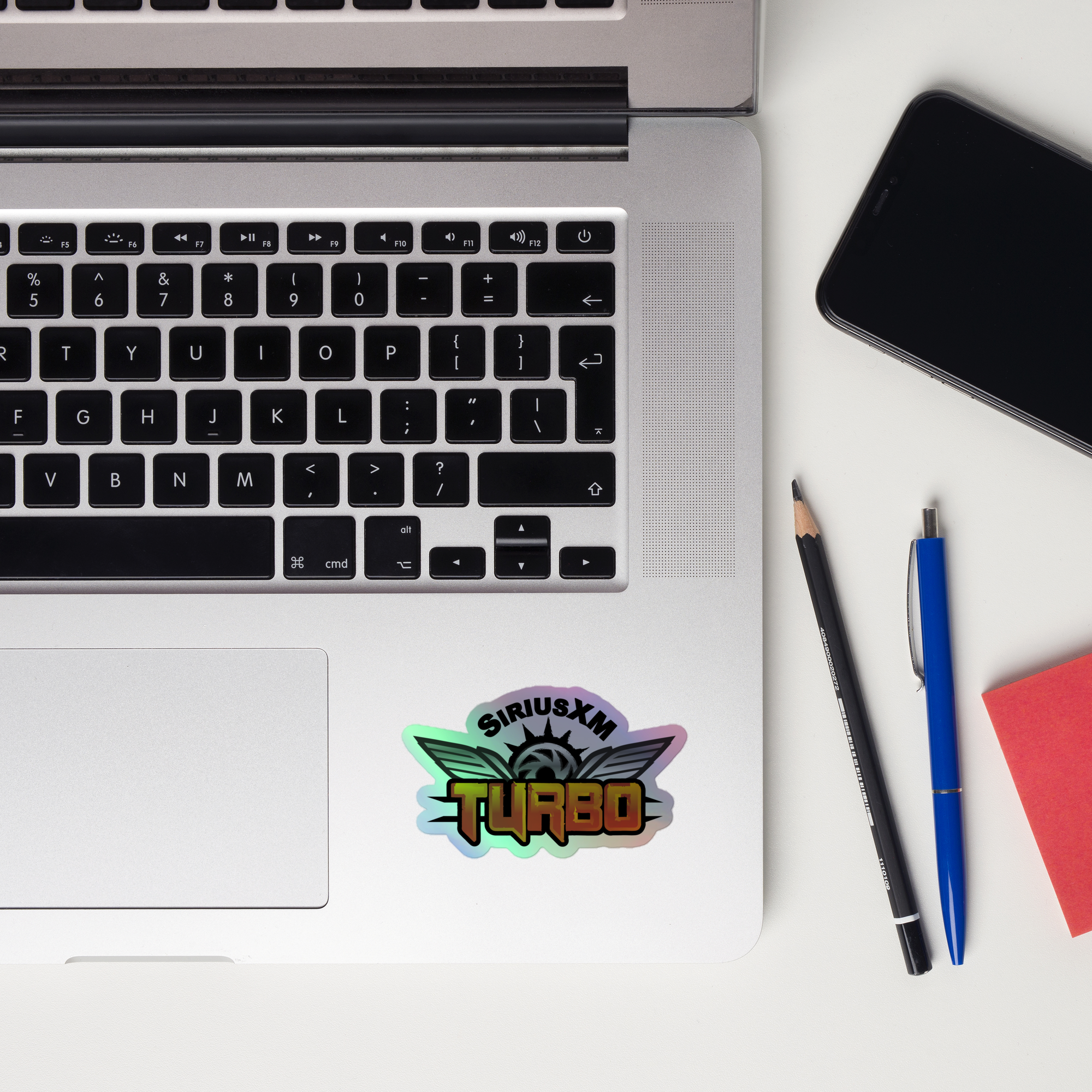 A laptop keyboard displaying a colorful 'SiriusXM Turbo' holographic sticker.