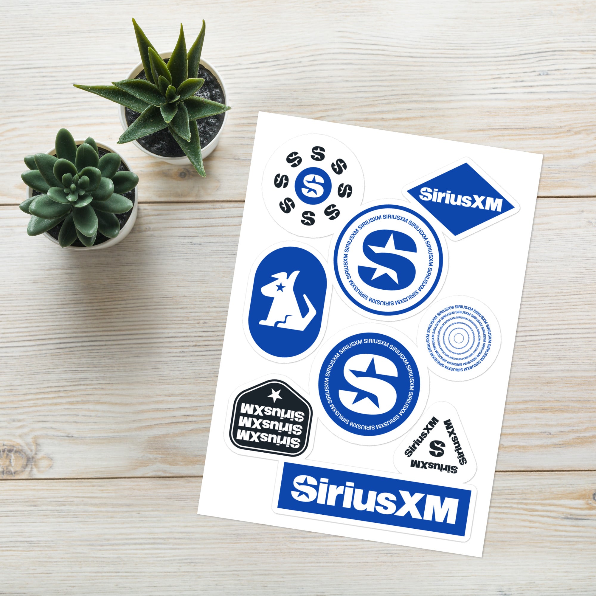 A collection of 'SiriusXM' stickers on grey desk in the background