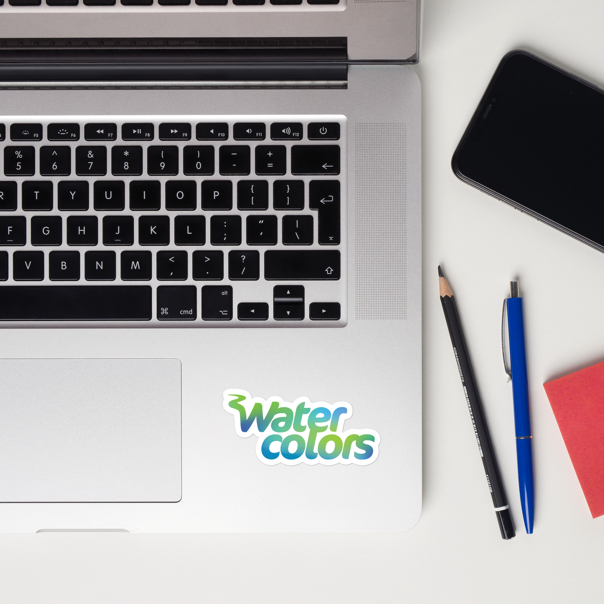 A laptop keyboard displaying a 'Watercolors' sticker.