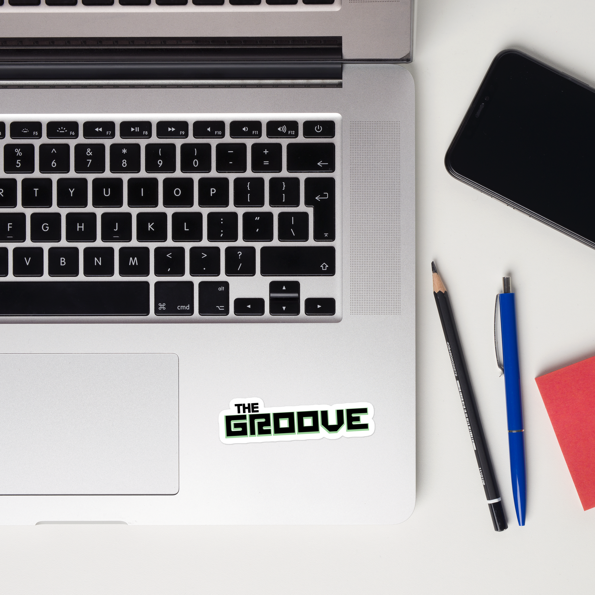 A laptop keyboard displaying a 'THE GROOVE' sticker.
