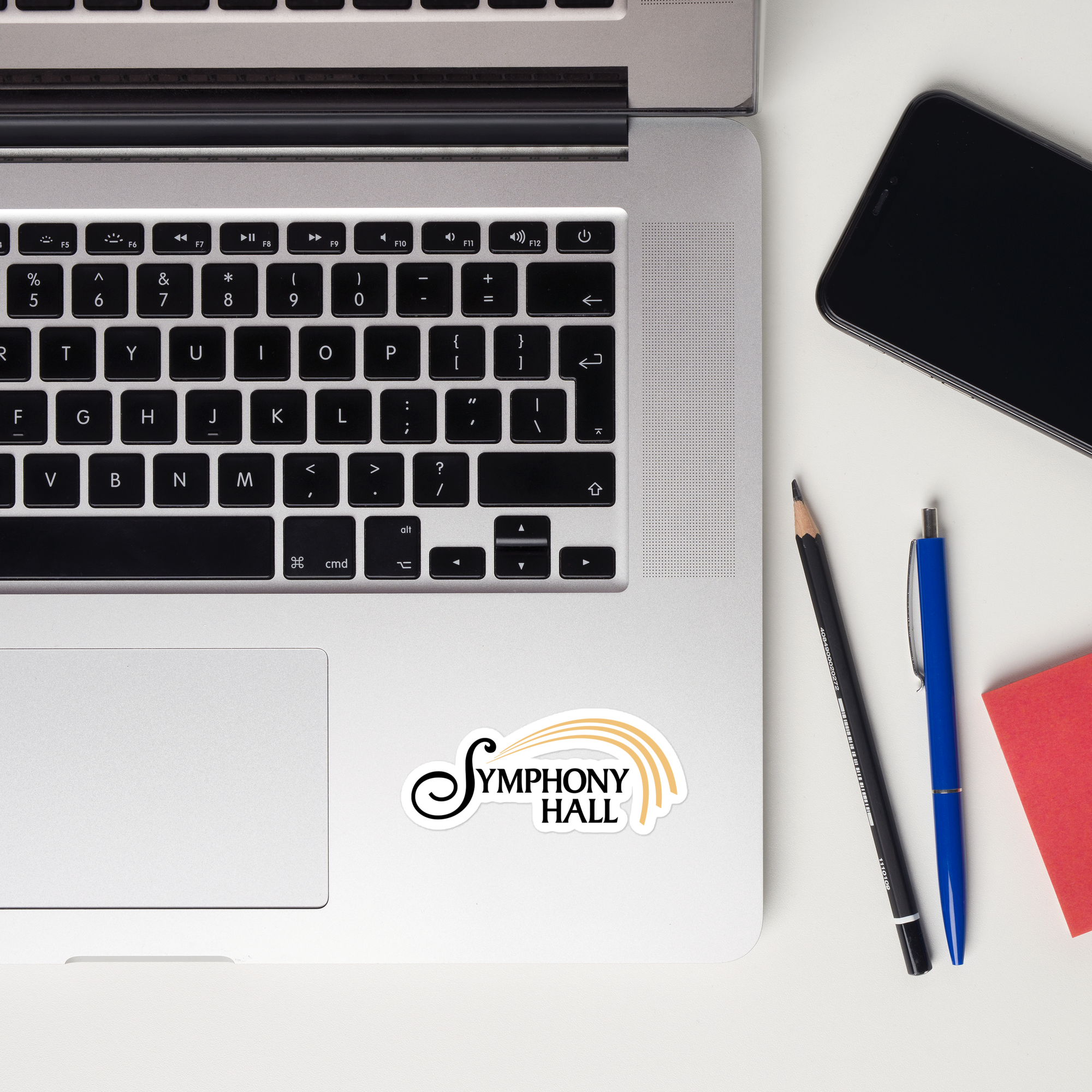 Laptop keyboard displaying a 'Symphony Hall' sticker on it.