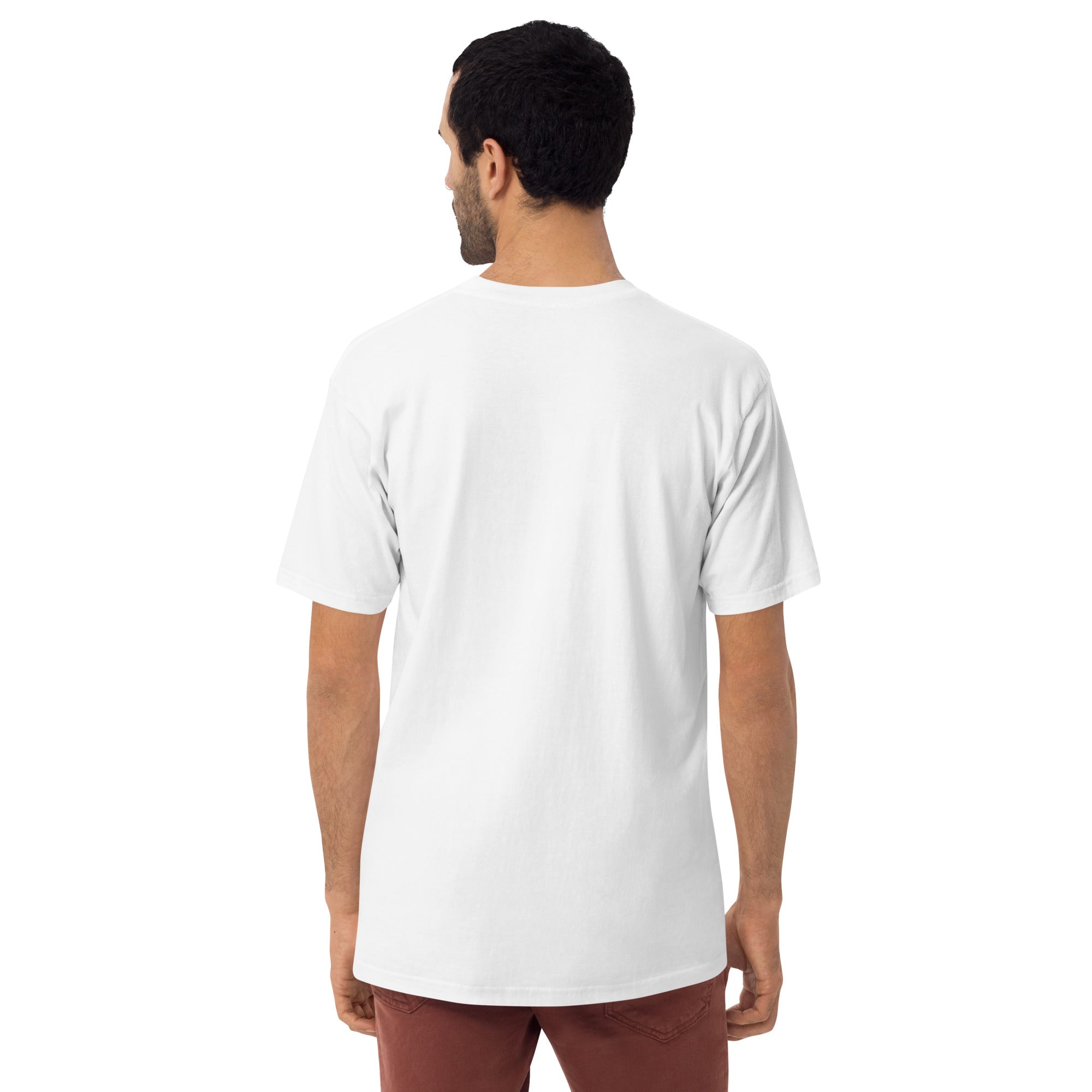 A man standing with his back to the camera wearing a plain white T-shirt and rust-colored pants, with no visible design on the back of the shirt.