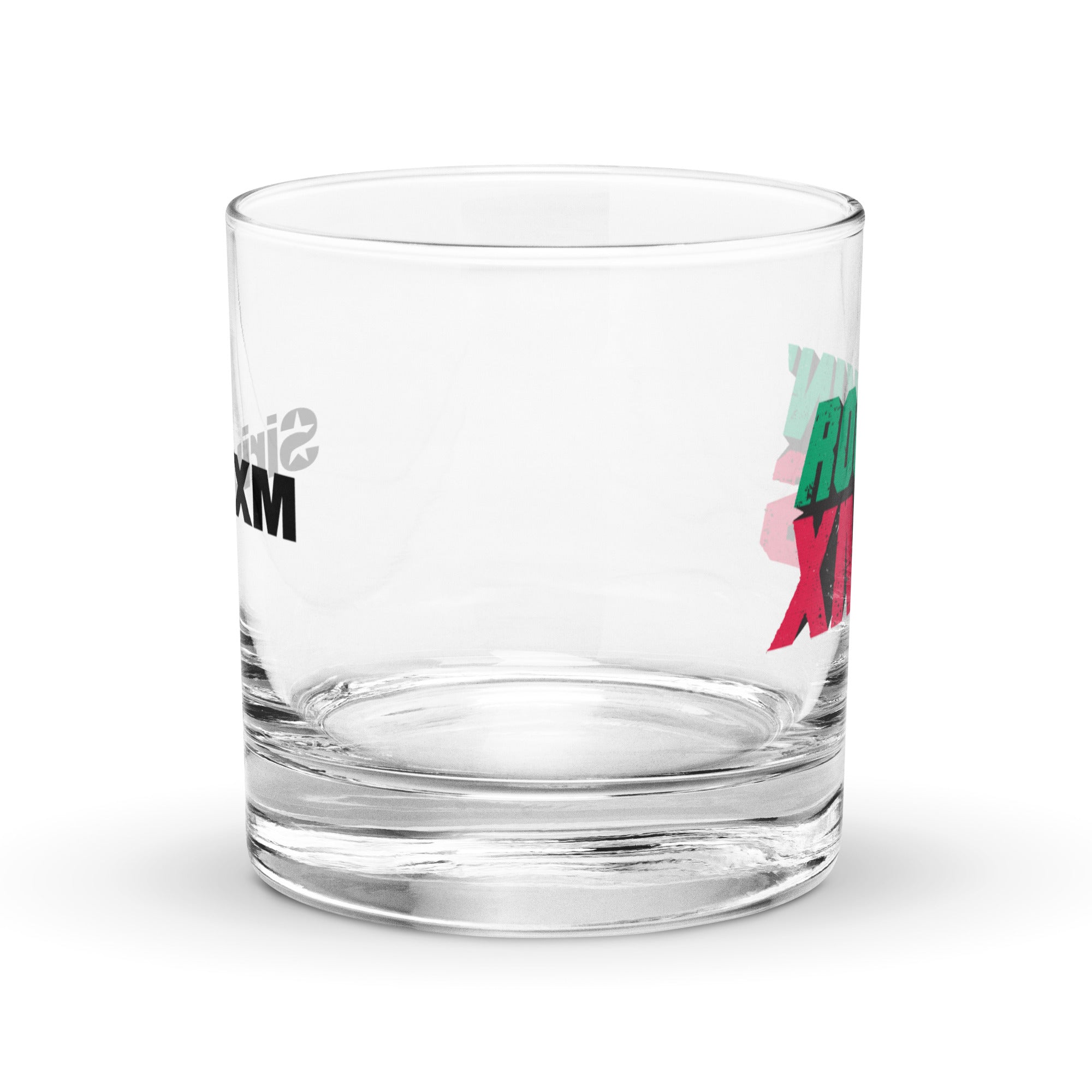 Side view of a clear rocks glass showing the ‘ROCKIN’ XMAS’ design in green and red block letters on the front, with part of the ‘SiriusXM’ logo visible through the back of the glass.