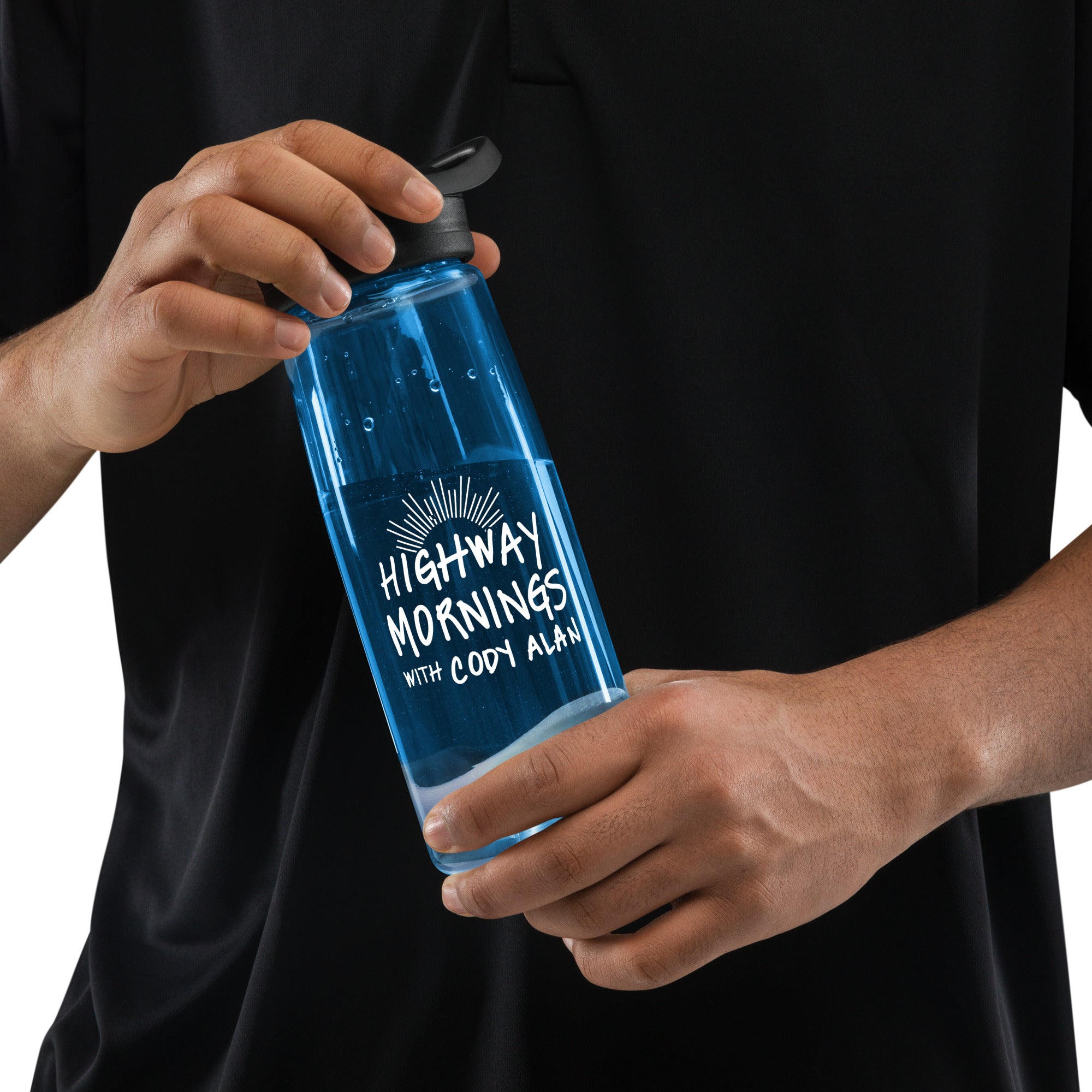 A man in a black shirt holding the blue CamelBak bottle, with the white 'HIGHWAY MORNINGS WITH CODY ALAN' logo and sunburst graphic clearly visible.