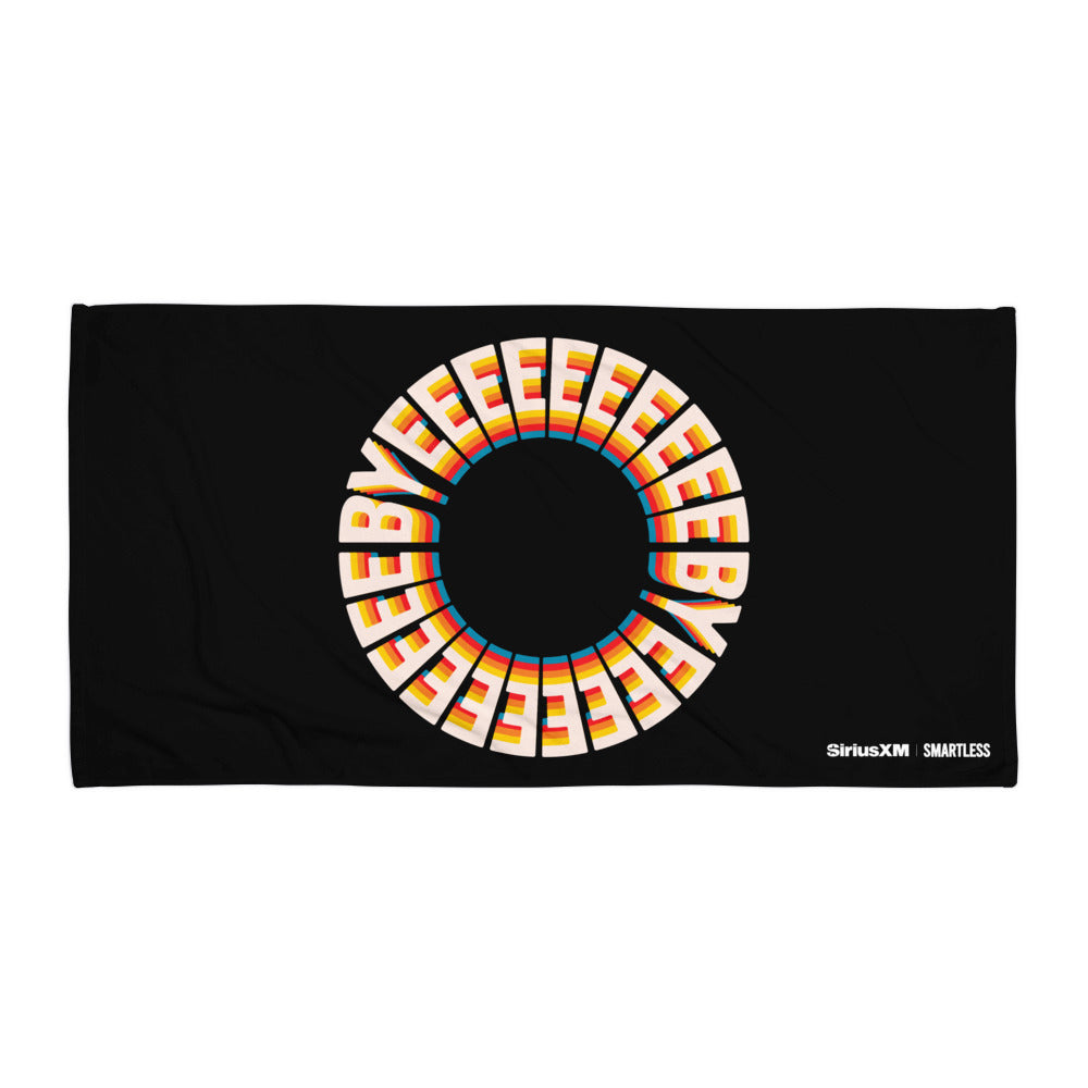 A black towel featuring a circular design made up of repeating text that reads 'BYEEEEEEEE' in bold, retro-style cream letters with orange, pink, blue, and yellow shadows. The text forms a full ring in the center of the towel. In the lower right corner, white logos read 'SiriusXM' and 'SMARTLESS'.