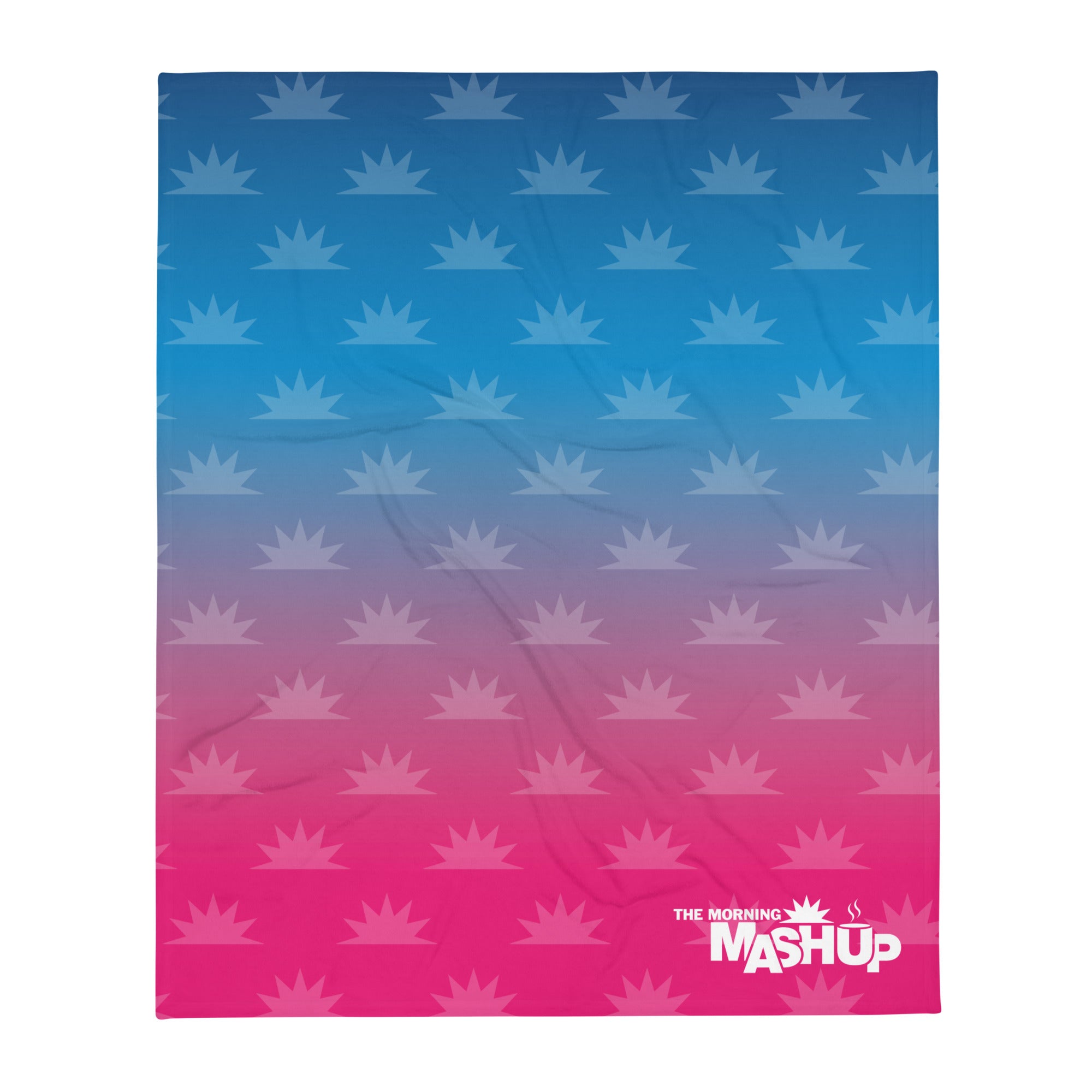 Blanket with a gradient from blue to pink featuring repeated starburst patterns and the text 'THE MORNING MASHUP' in white.