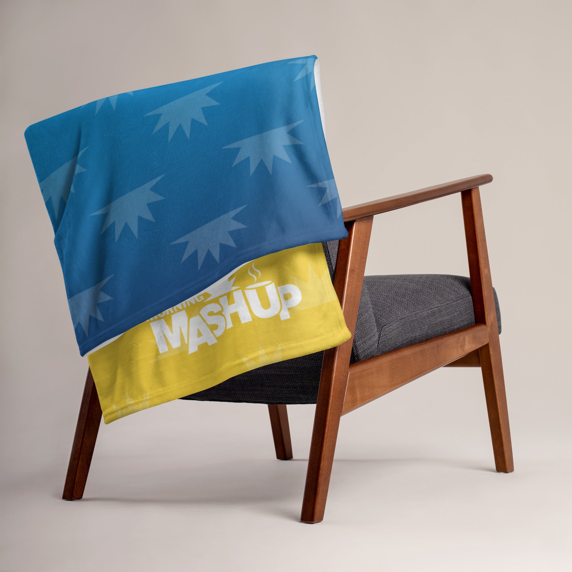 A blue and yellow blanket with a graphic design draped over the back of a wooden chair.