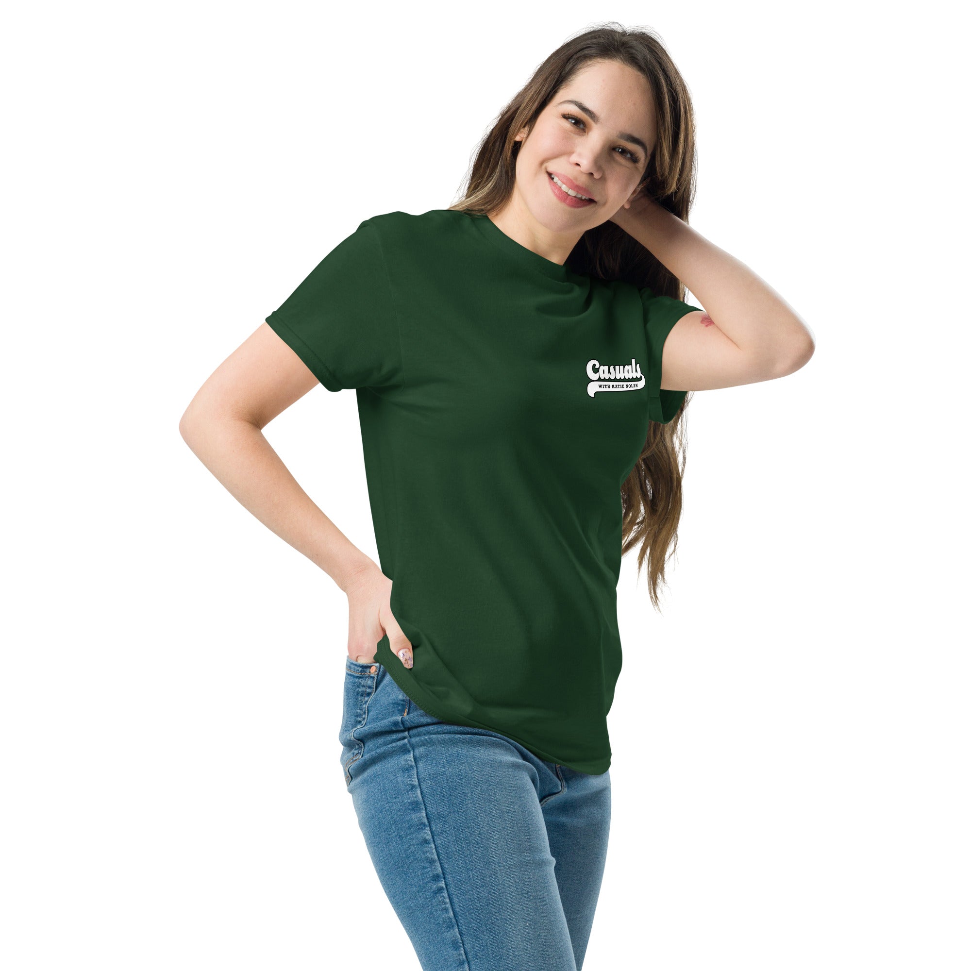 Woman wearing a forest green short-sleeve t-shirt with a small white chest logo on the left. The logo features 'Casuals' in bold with 'WITH KATIE NOLAN' underneath.
