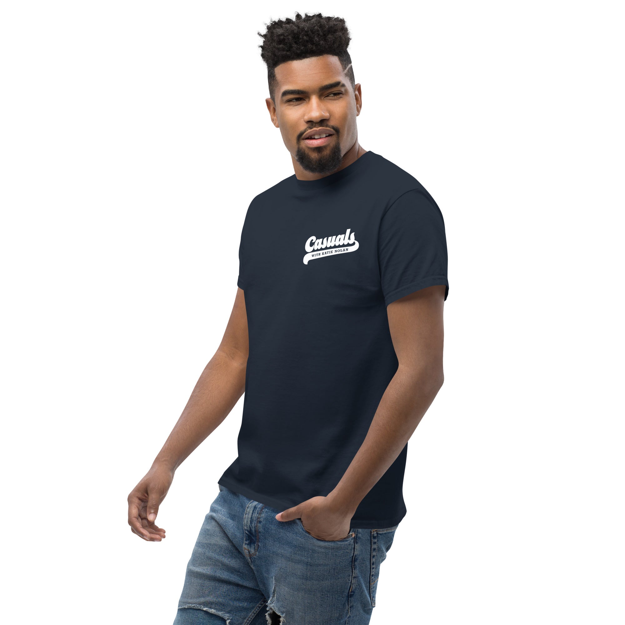 Man wearing a navy short-sleeve t-shirt with a small white left chest logo reading 'Casuals' in bold with 'WITH KATIE NOLAN' underneath.