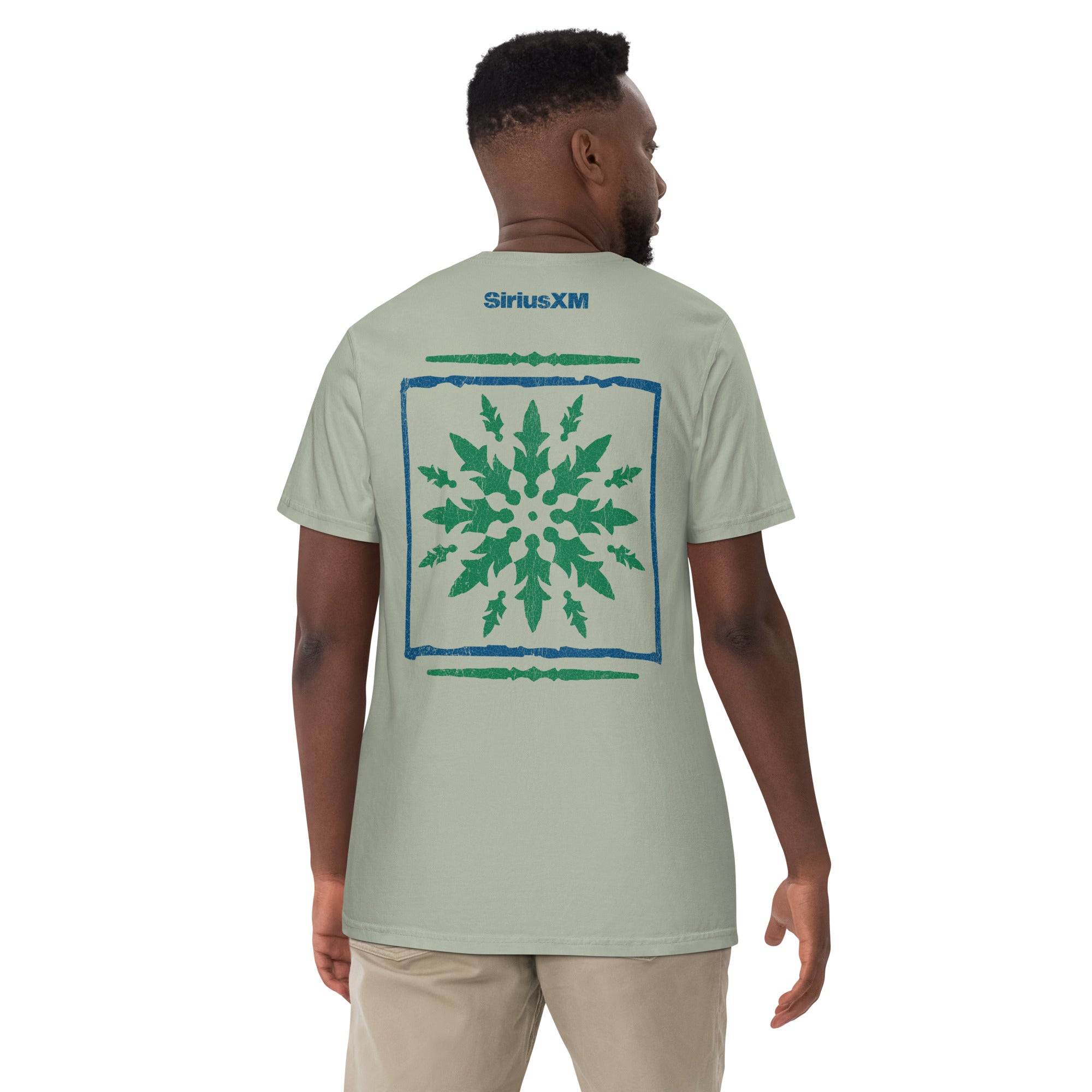 A man is shown from behind wearing the same T-shirt. The large back graphic is fully visible, featuring the quilt-like green leafy design and blue border, with a small blue 'SiriusXM' logo above it.