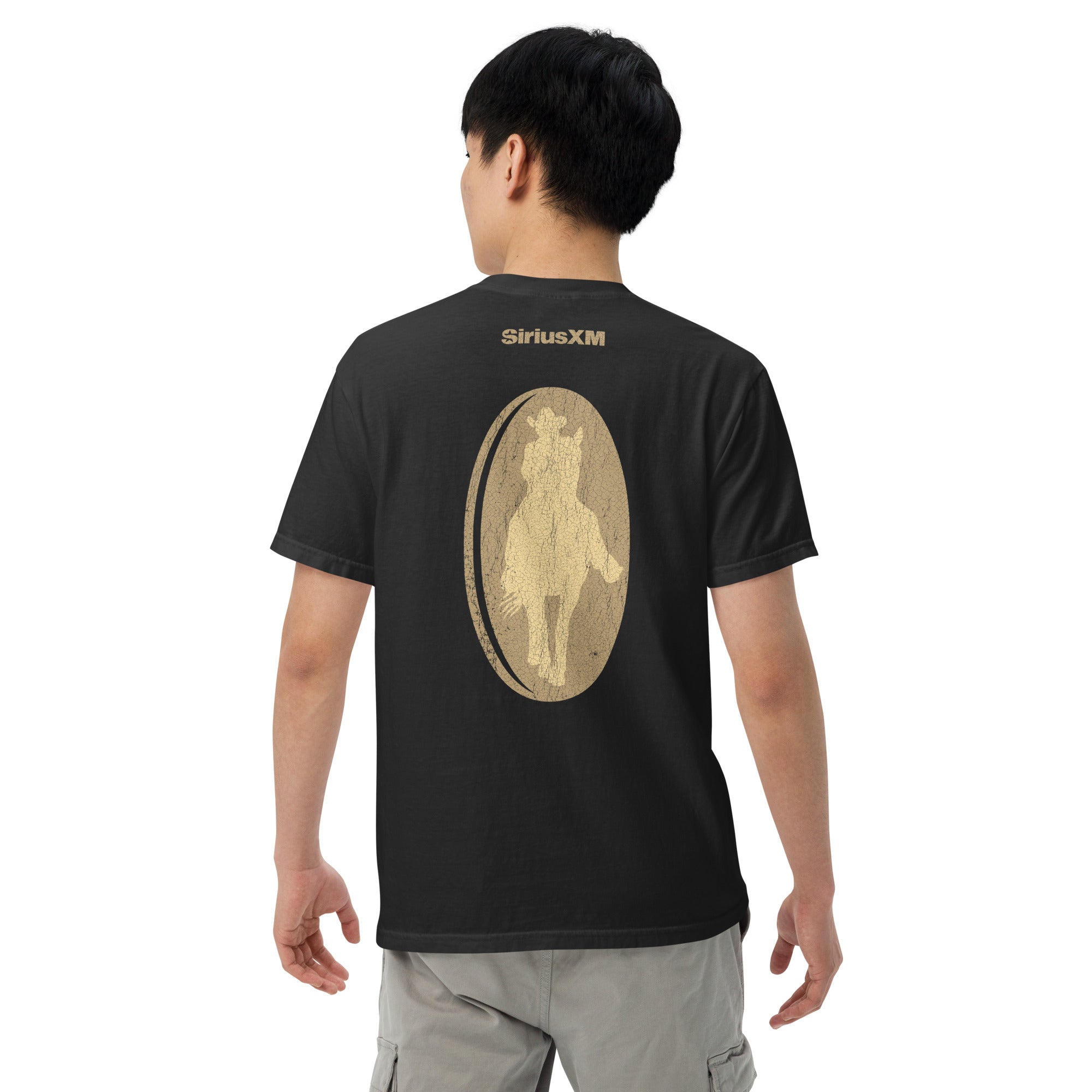 Back view of a man wearing the same black T-shirt, showing a large distressed gold oval graphic of a cowboy on horseback in the center back. The word 'SiriusXM' appears above the graphic in gold lettering.