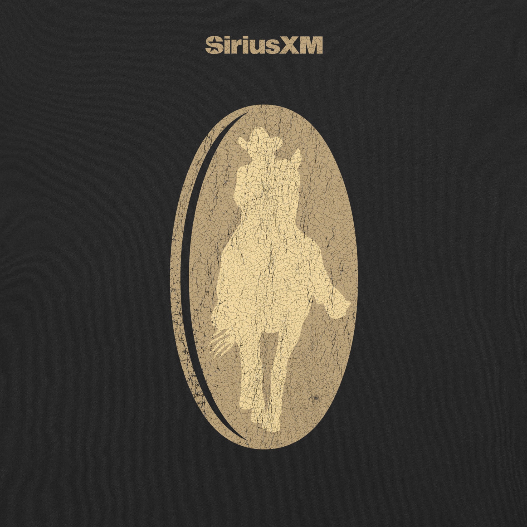 Close-up of the back design on the black T-shirt. Centered on the upper back is the word 'SiriusXM' in distressed gold text, with a large textured gold oval below it containing the silhouette of a cowboy on horseback.