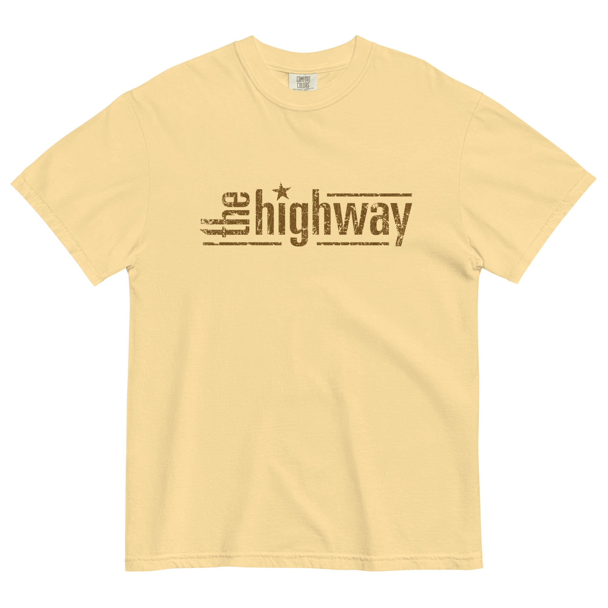 Flat lay of a pale yellow T-shirt showing the distressed brown logo ‘the highway’, with a star used as the dot on the i in ‘highway’.