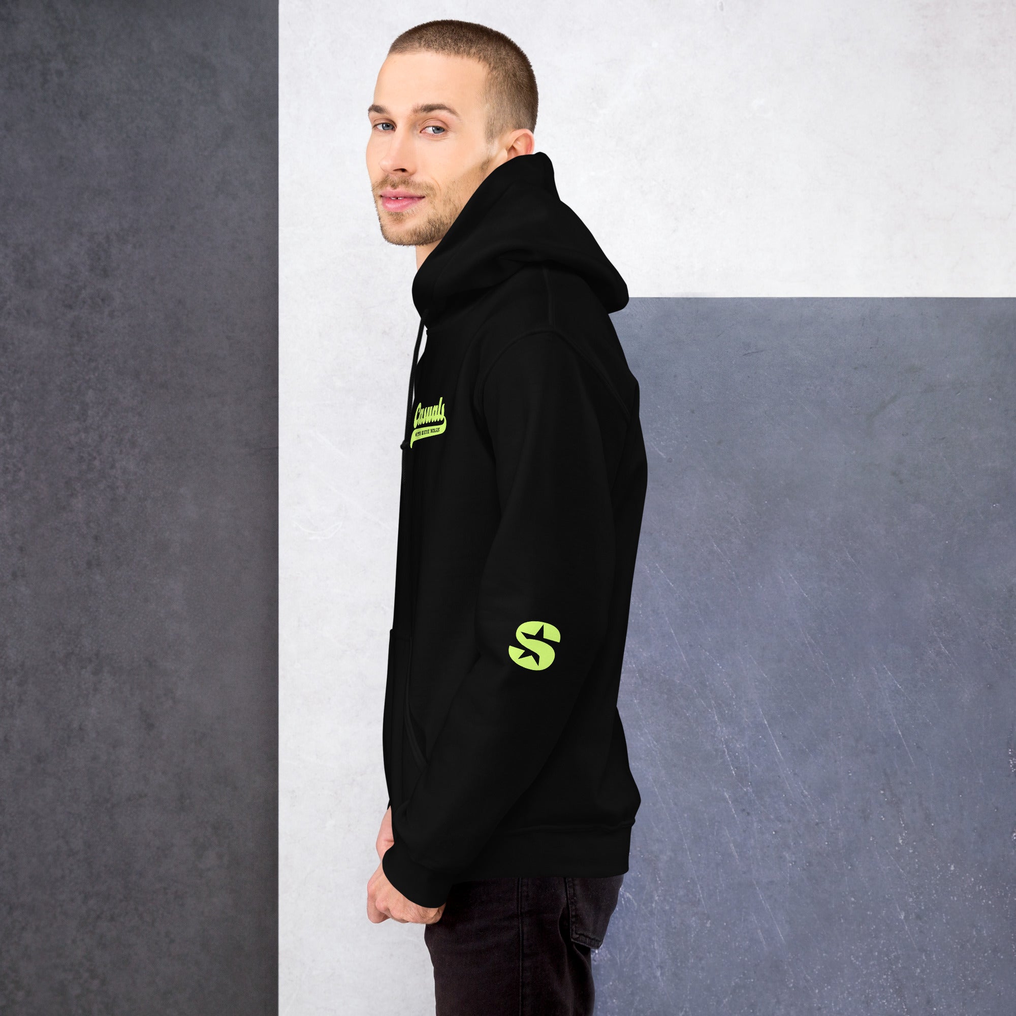A man in profile wearing the hoodie, showing the left chest placement of the 'Casuals with Katie Nolan' graphic and SiriusXM’s 'S-Star' logo on the outer right sleeve, both in light green.