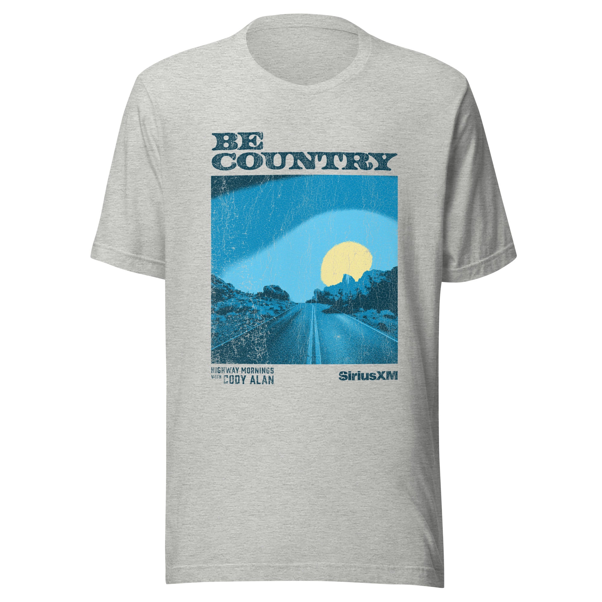Heather gray unisex t-shirt featuring a distressed blue and yellow graphic of a road and sunrise with the words 'BE COUNTRY' at the top, and 'HIGHWAY MORNINGS WITH CODY ALAN' and 'SiriusXM' at the bottom corners.