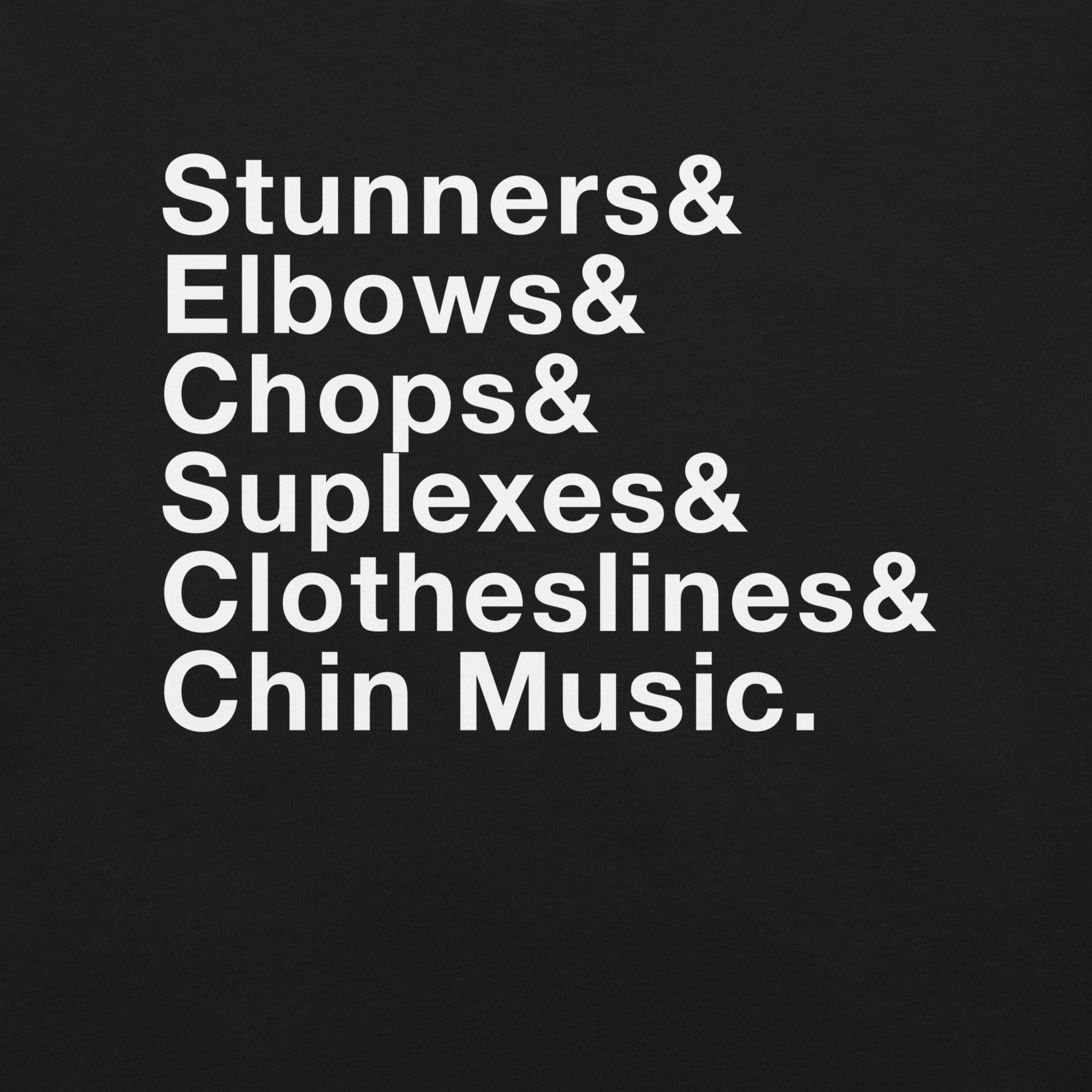 Close-up of a black T-shirt showing bold white stacked text that reads: 'Stunners& Elbows& Chops& Suplexes& Clotheslines& Chin Music.'