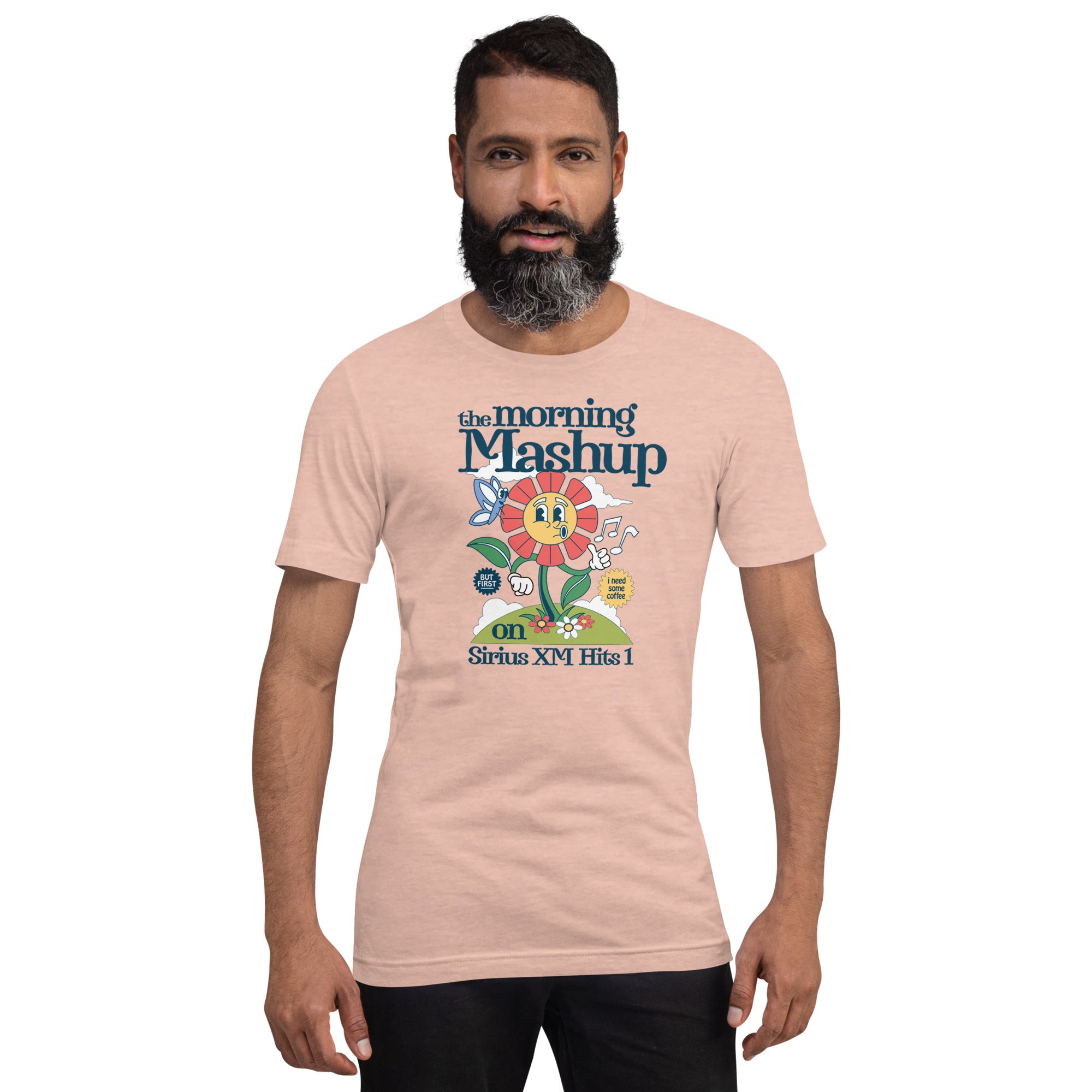 Man wearing a peach-colored T-shirt with a colorful graphic of a friendly flower character and the text 'the morning Mashup on Sirius XM Hits 1.'
