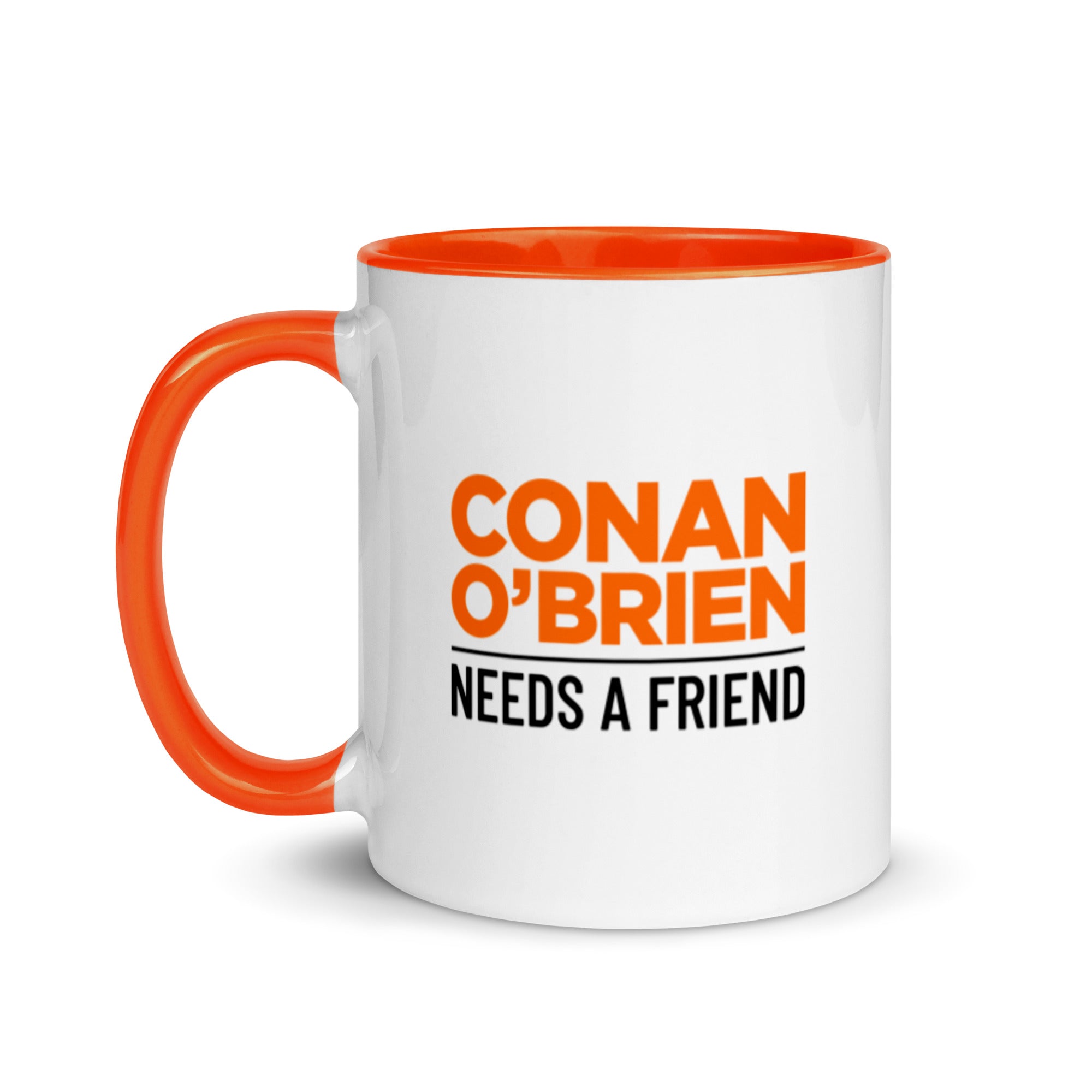 White mug with orange interior and handle on the left side, featuring black and orange 'CONAN O'BRIEN NEEDS A FRIEND' logo.