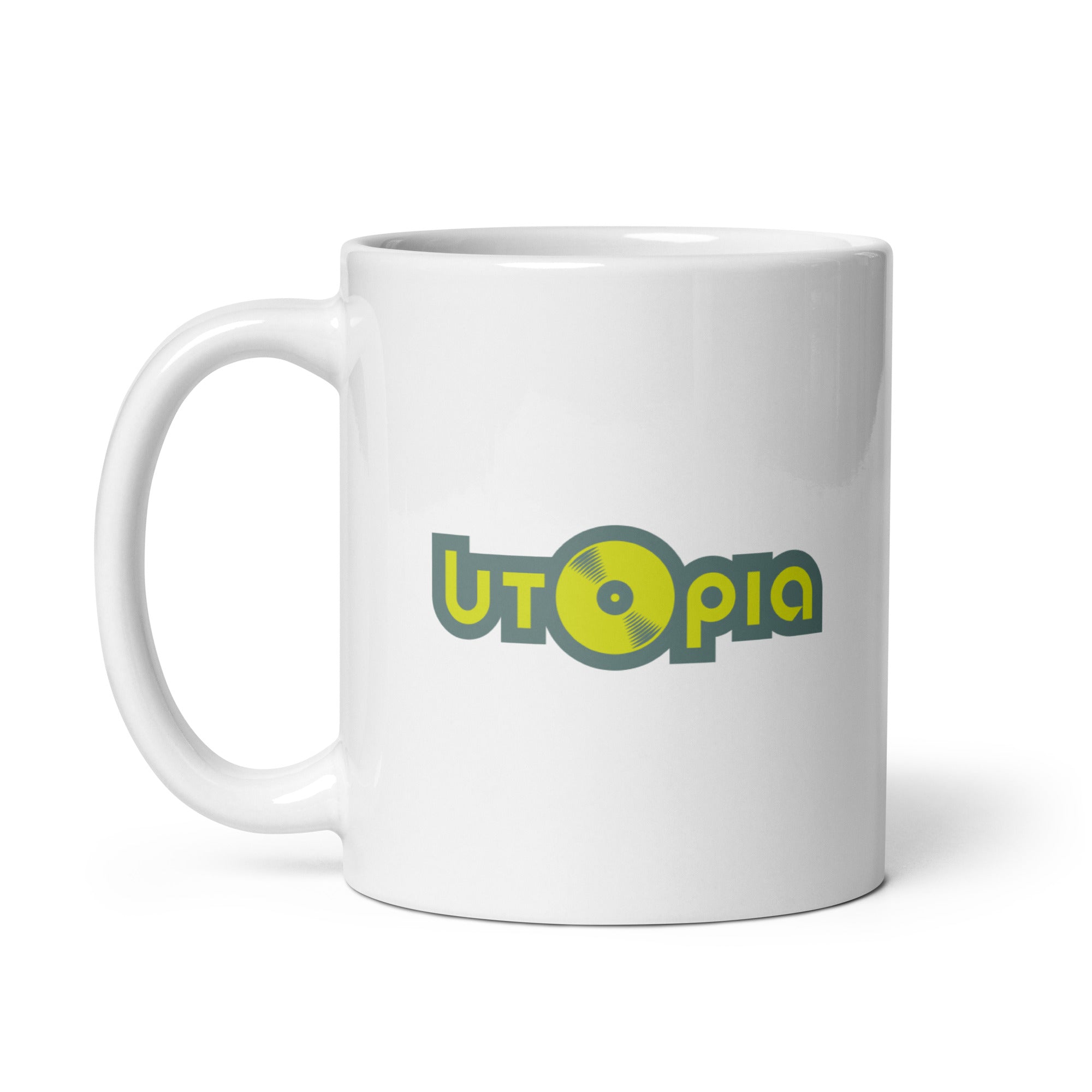 A white mug with the logo 'UTOpia,' featuring a vinyl record design in yellow and green.