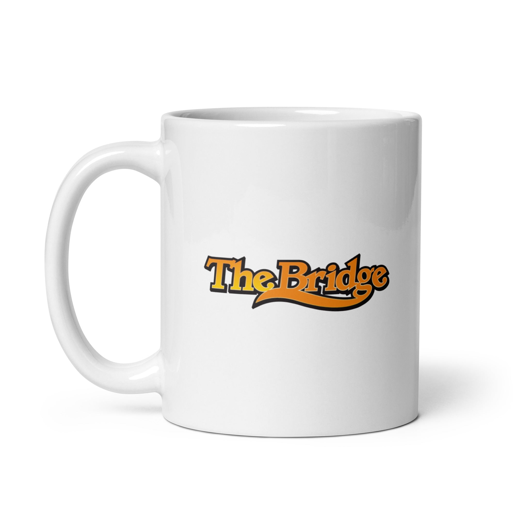 White coffee mug featuring the 'The Bridge' logo in orange and black.
